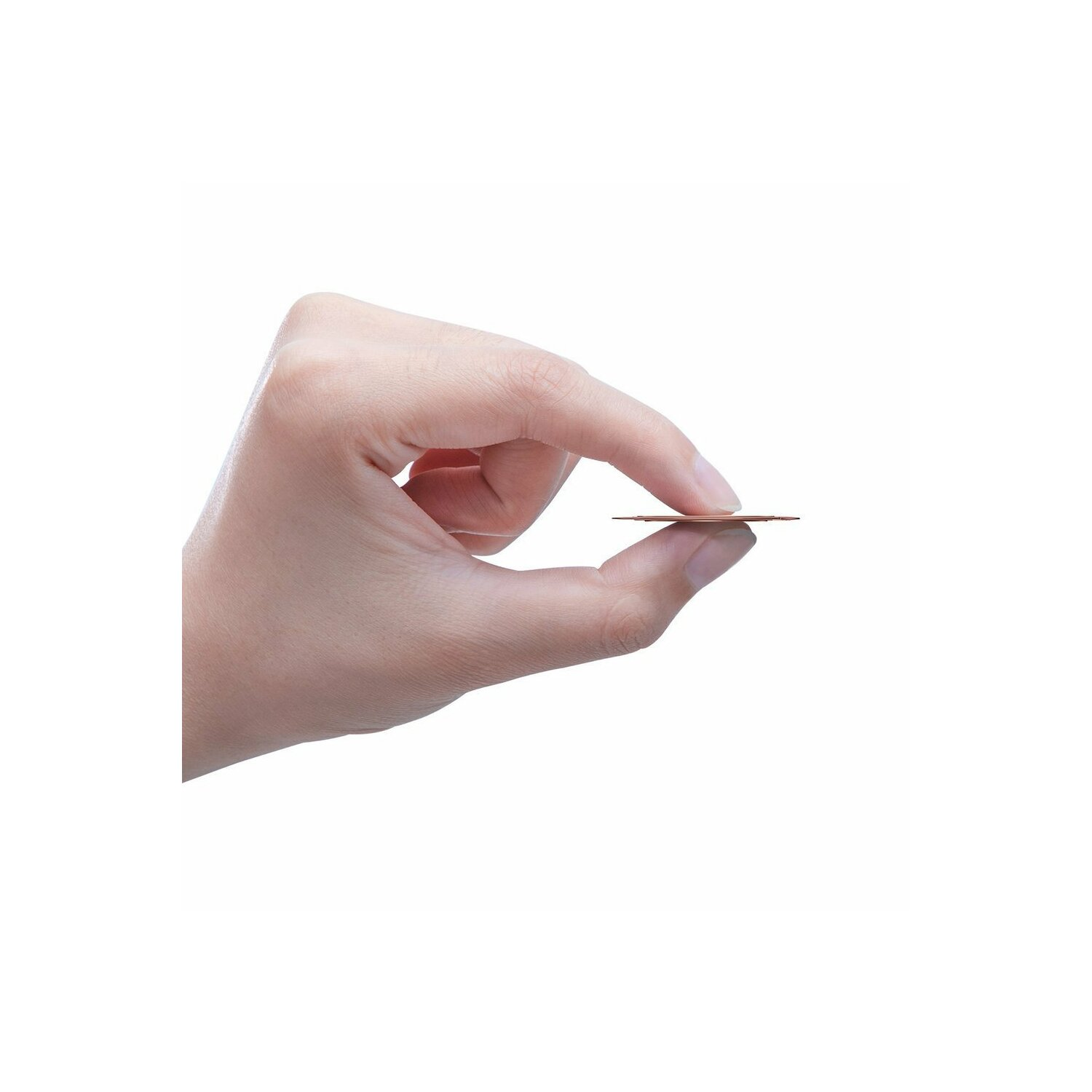 Dłoń trzymająca cienki, brązowy, okrągły przedmiot między palcami.