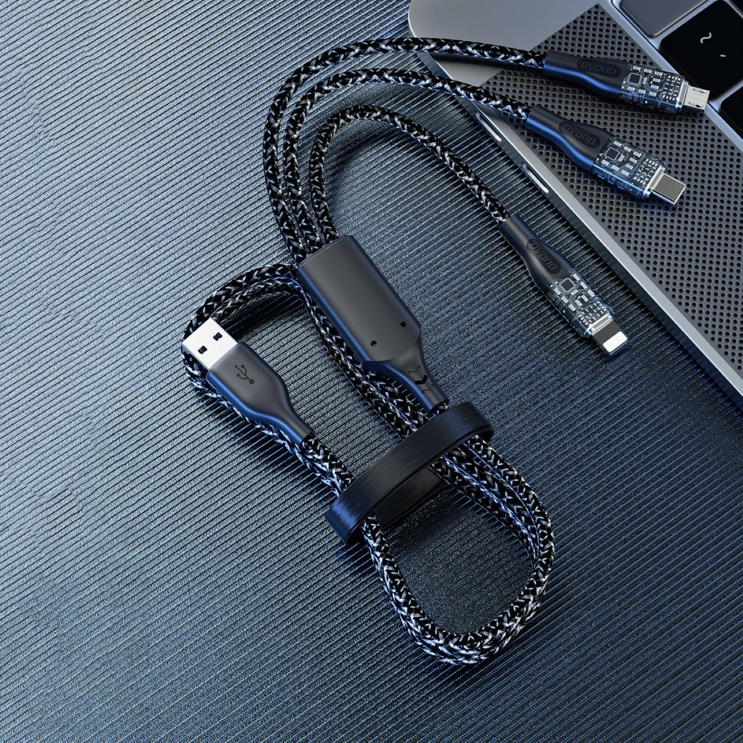 Ein geflochtenes USB-Kabel mit drei USB-C-Anschlüssen. Ein schwarzer Riemen hält das Kabel zusammen.