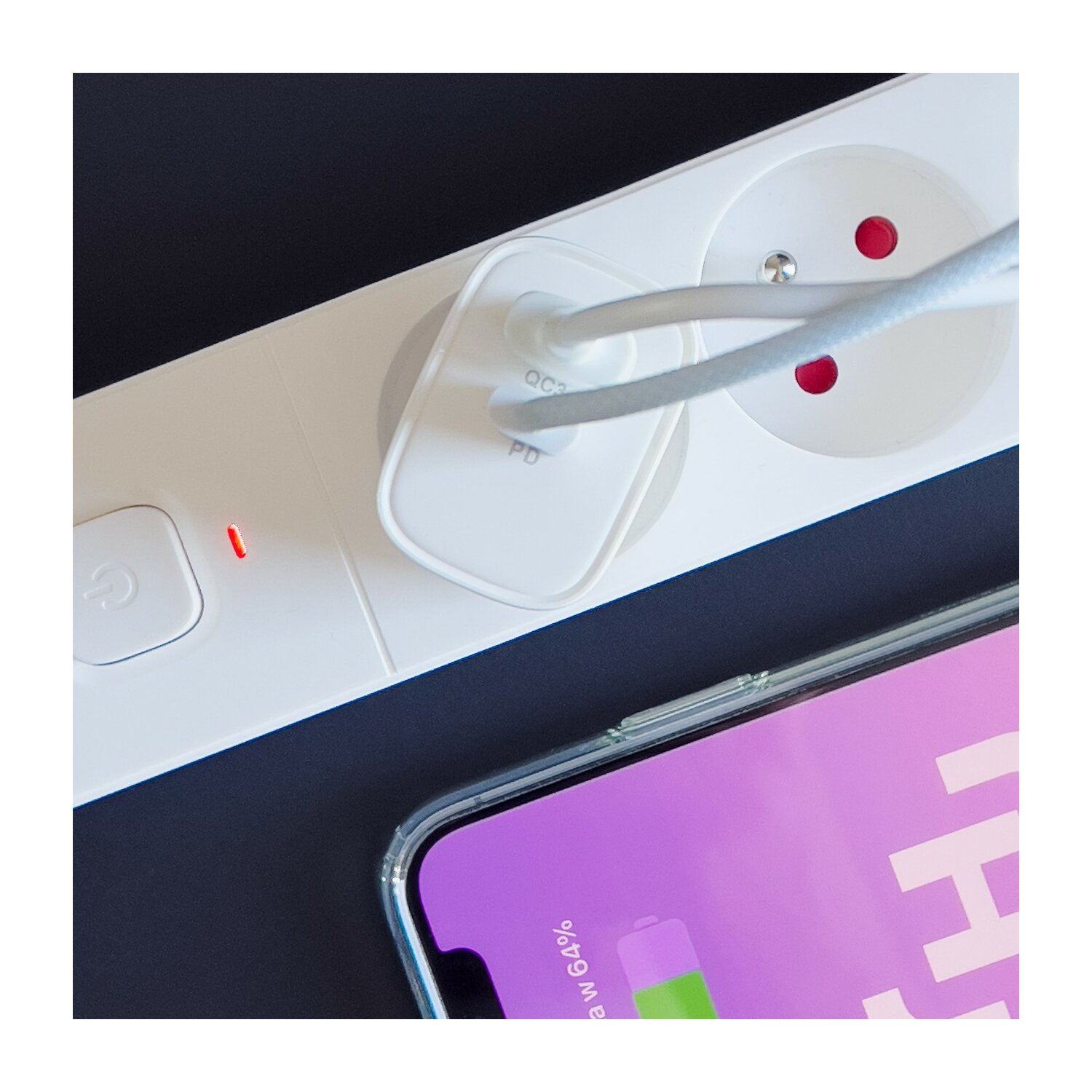 Weiße Steckdosenleiste mit Ladestecker und ladendem Telefon, das einen Akku anzeigt.