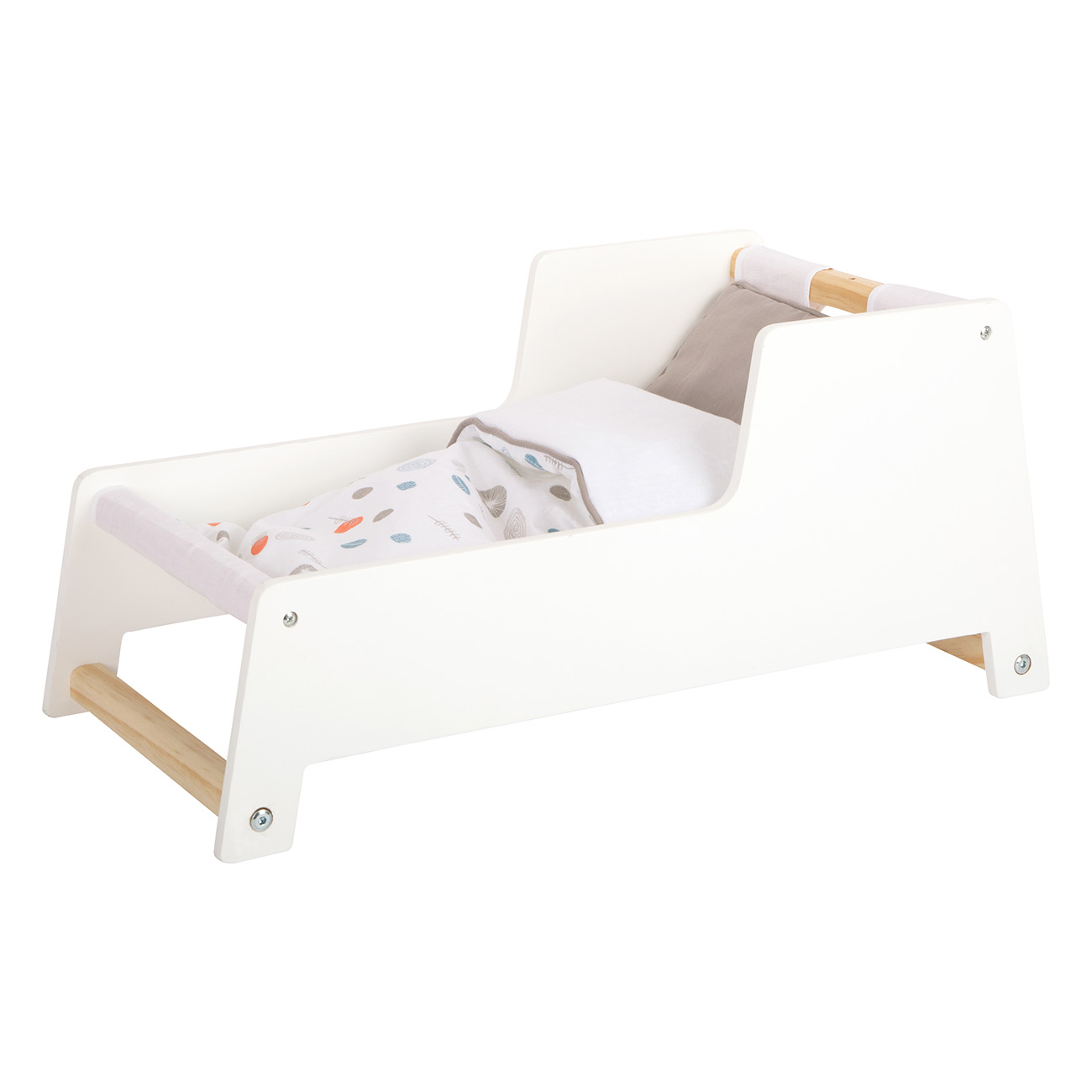Ein weißes Holzbett für Puppen mit einer Puppe darin. Es hat eine Decke und ein Kissen mit hellem Muster.