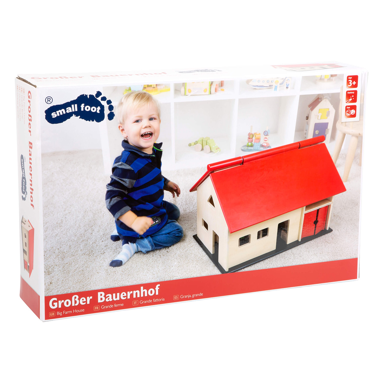 Kind lächelt neben einem Spielzeugbauernhof. Die Box zeigt Haus und Spielzeug.
