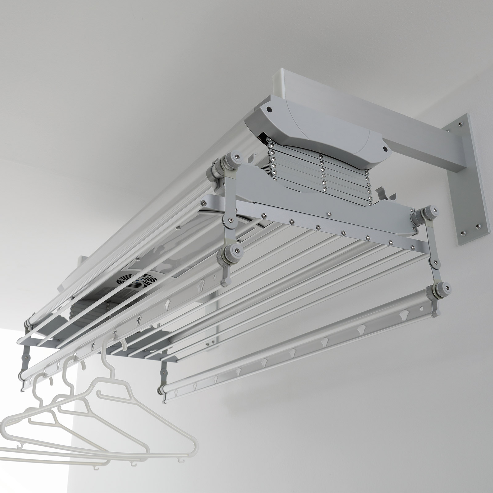Stendibiancheria a soffitto bianco, con grucce bianche, sfondo bianco.