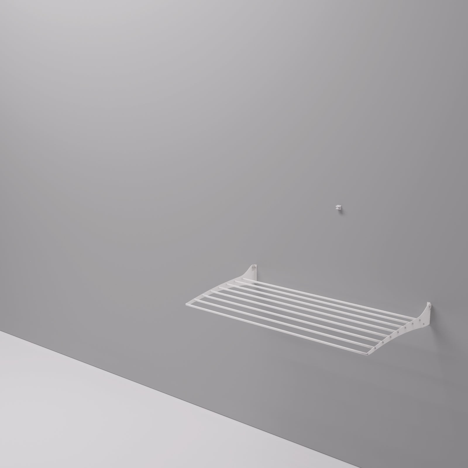 Stendibiancheria bianco a parete contro un muro grigio. Design semplice.