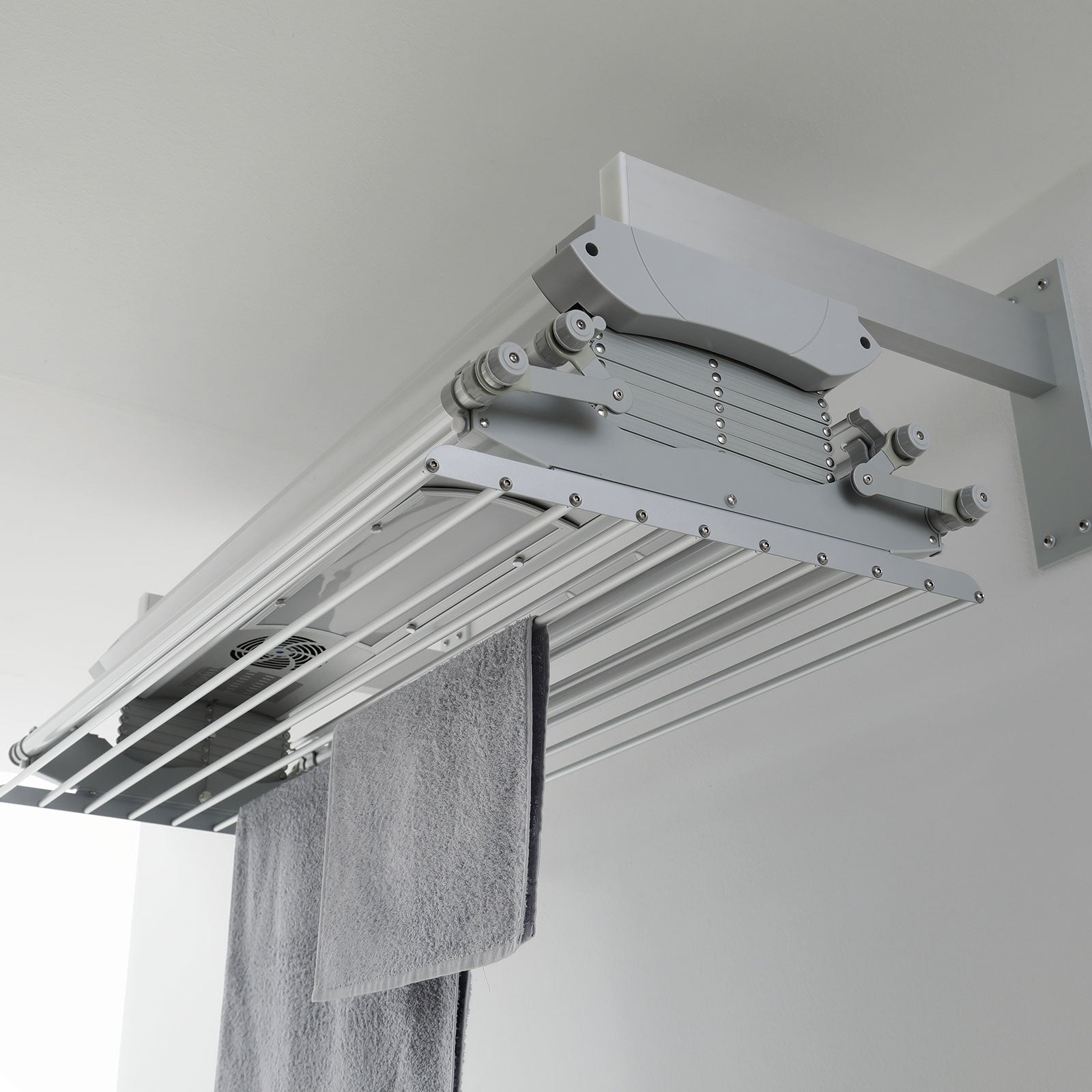 Asciugatrice a soffitto con asciugamani grigi appesi. Sfondo bianco.