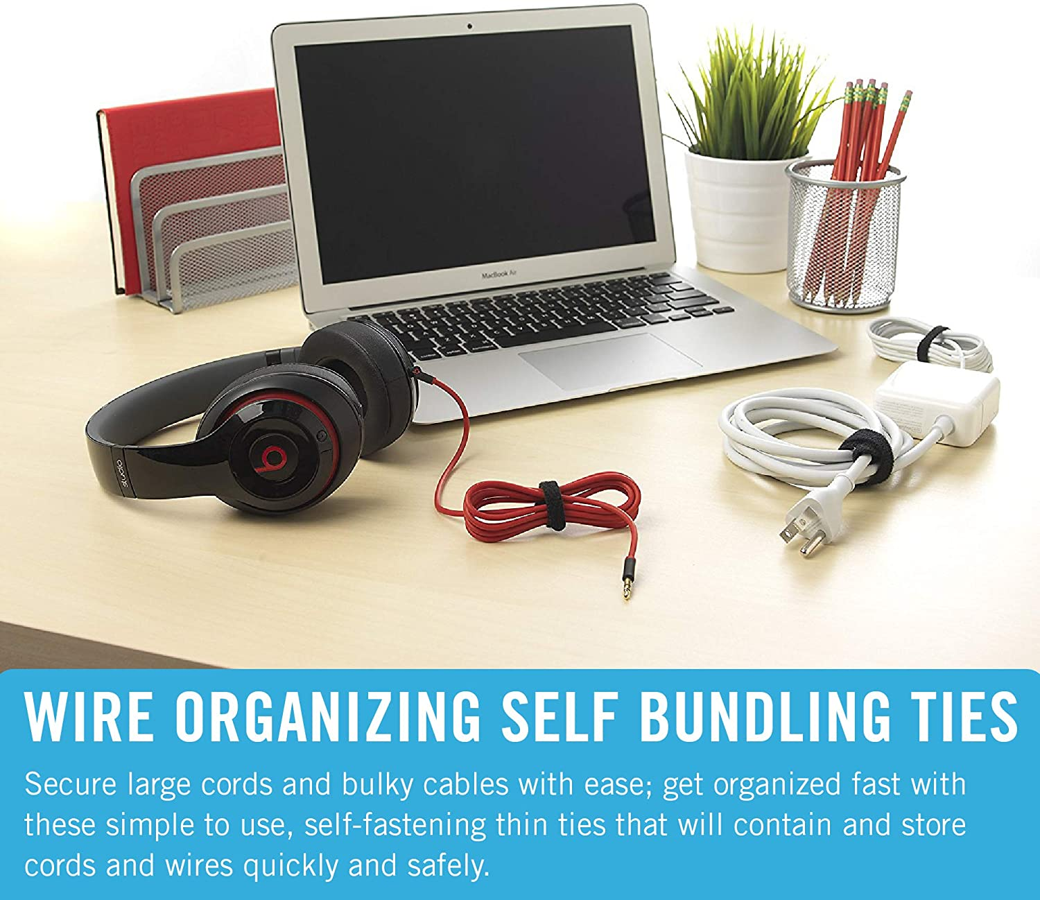 A desk with a laptop, headphones, and cables held together by red and black cable ties.