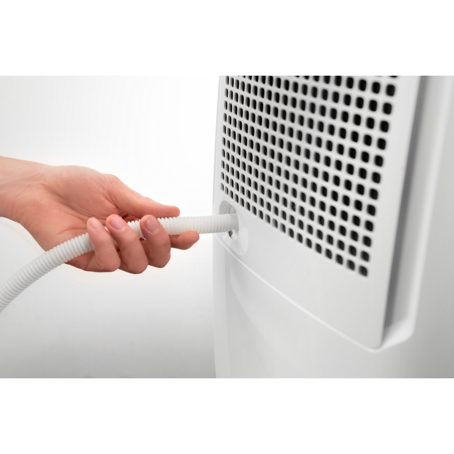 Hand verbindet weißen Schlauch mit einem weißen Gerät mit Grill. Weißer Hintergrund.