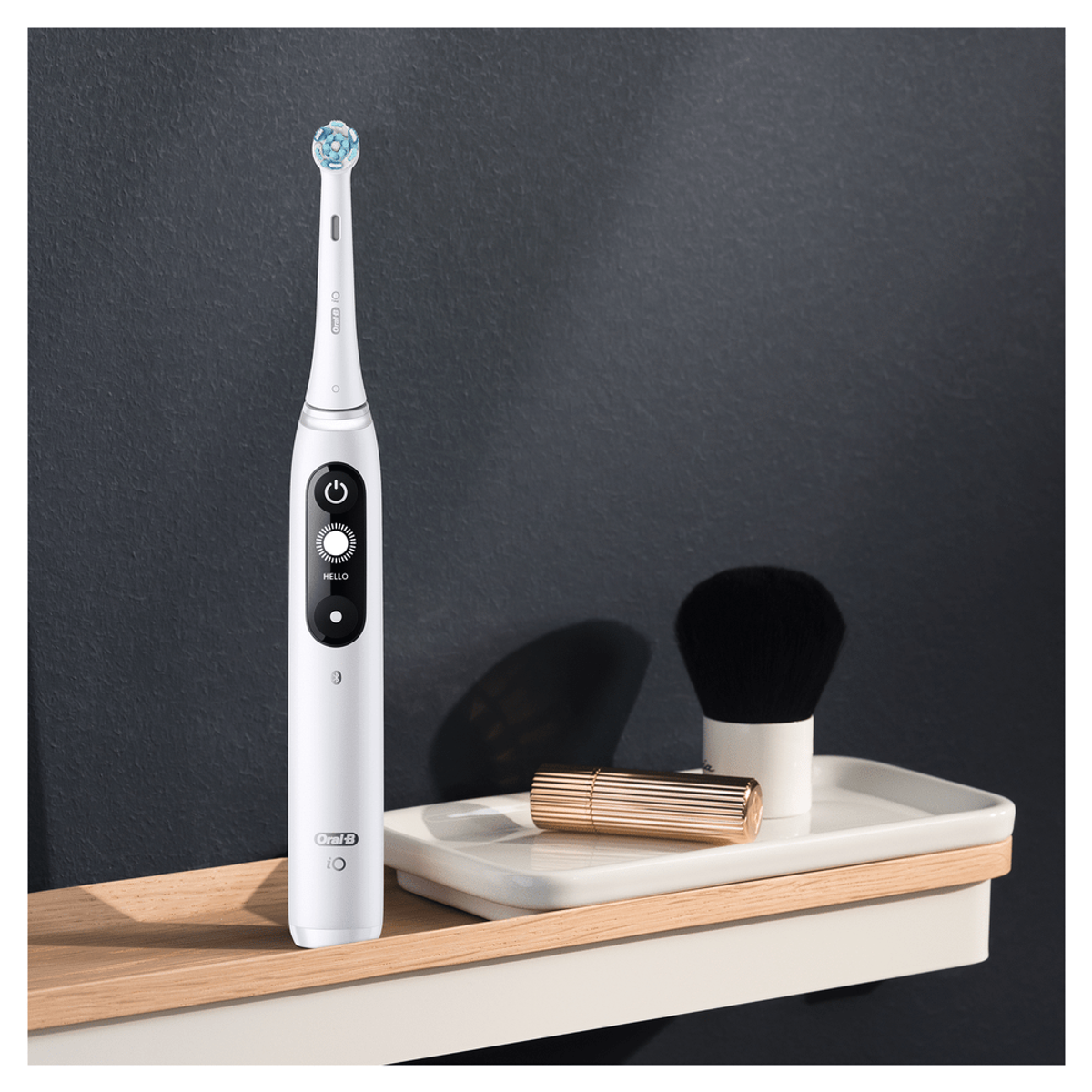 Cepillo de dientes blanco con juego de accesorios, colocado en una estantería de madera.