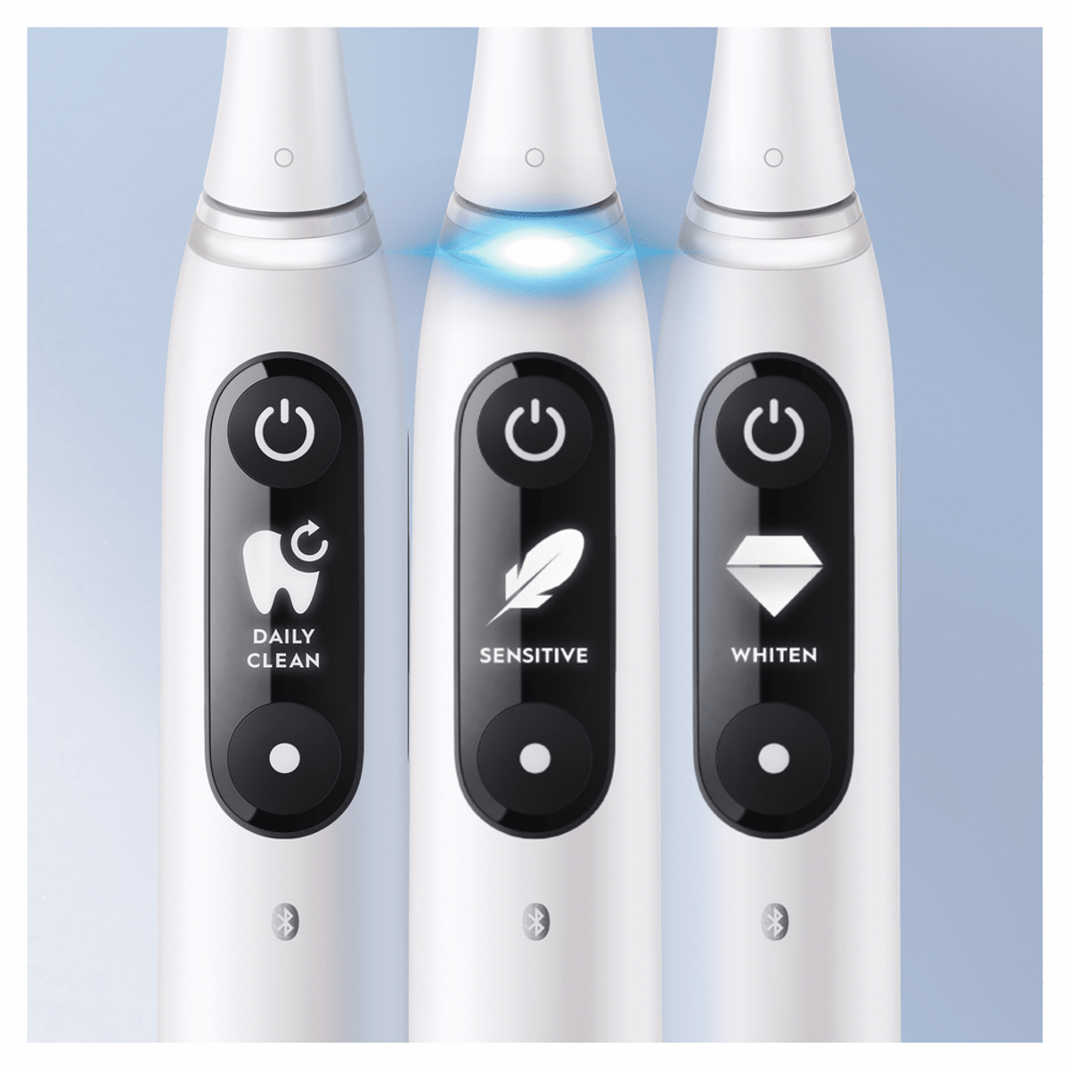 Tres cepillos de dientes eléctricos blancos con diferentes iconos de modo de limpieza.