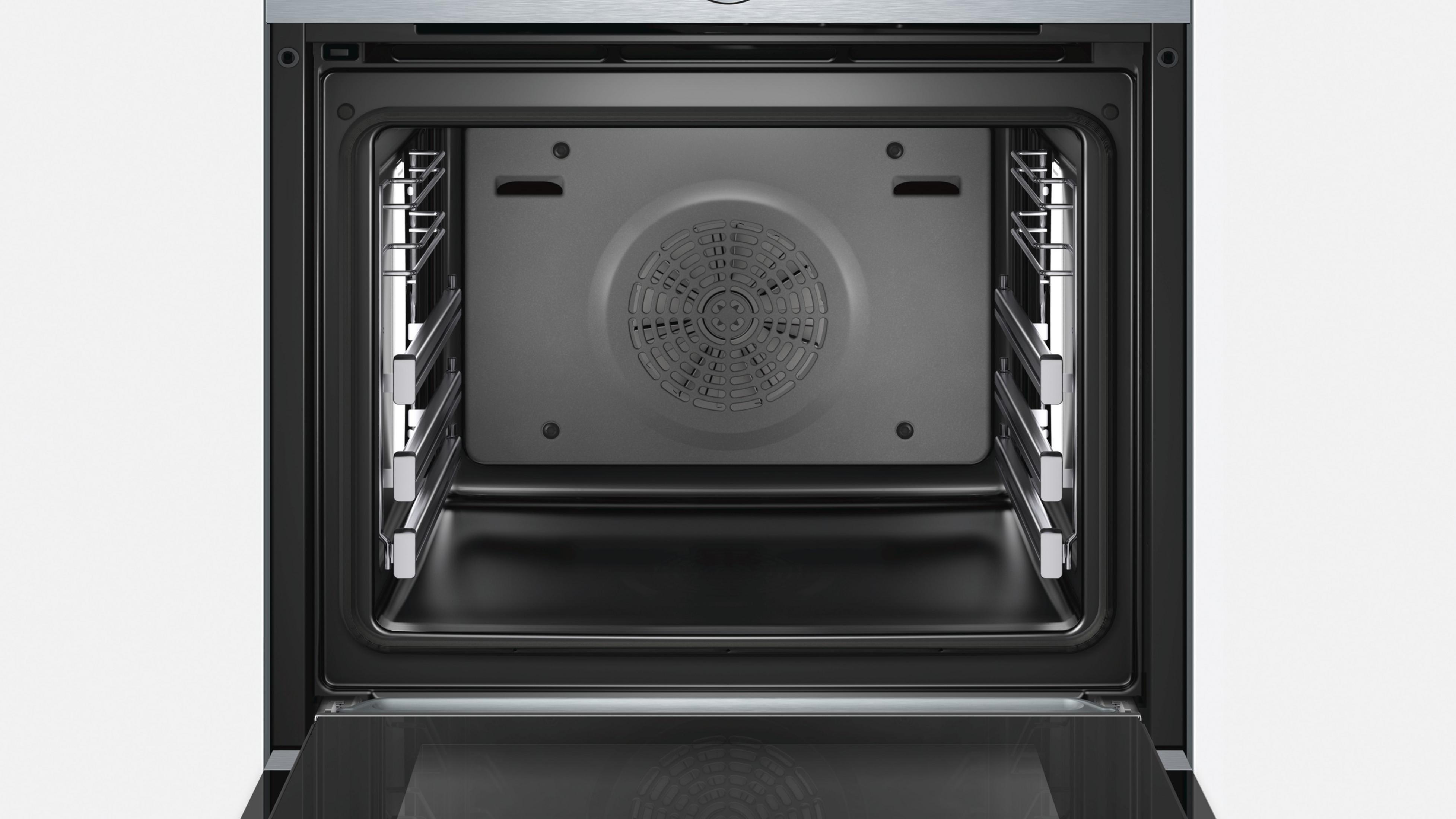Intérieur de four ouvert avec ventilateur, grilles et cadre de porte noir.