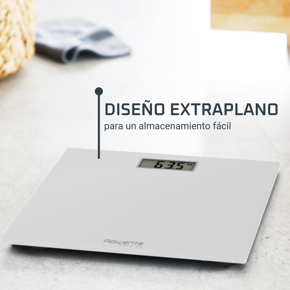 Báscula blanca muestra 63,5 kg. Texto: 'Diseño Extraplano'. Toalla gris y cesta tejida en el fondo.