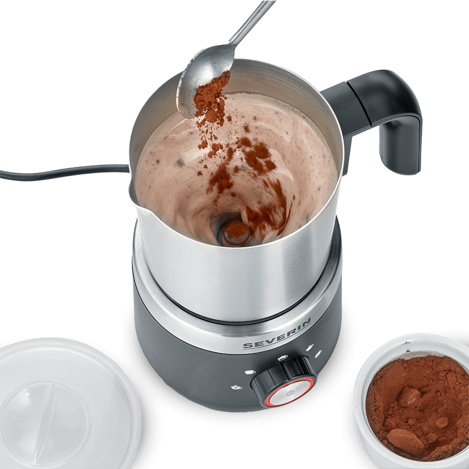 Maszyna do spieniania mleka z proszkiem kakaowym dodawanym łyżką. Widoczne są inne elementy.