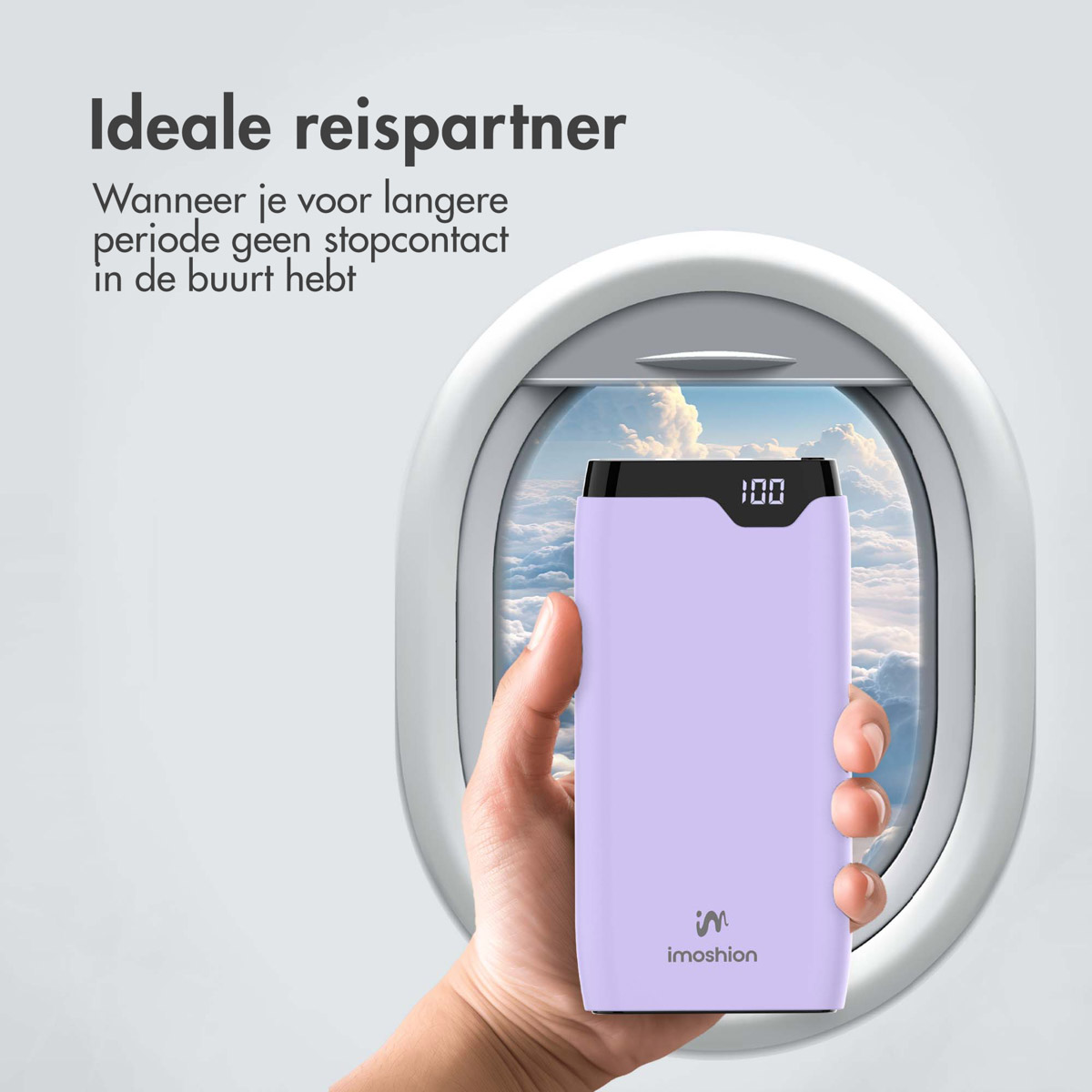 Eine Hand, die eine lila Powerbank hält, sichtbar durch ein Fenster mit Himmelsblick.