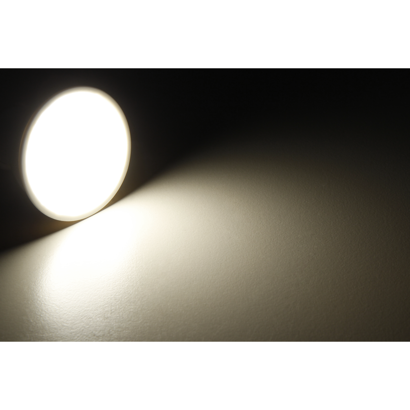 Nahaufnahme eines hellen Lichts, das auf eine Oberfläche scheint und einen Licht- und Schattengradienten erzeugt.