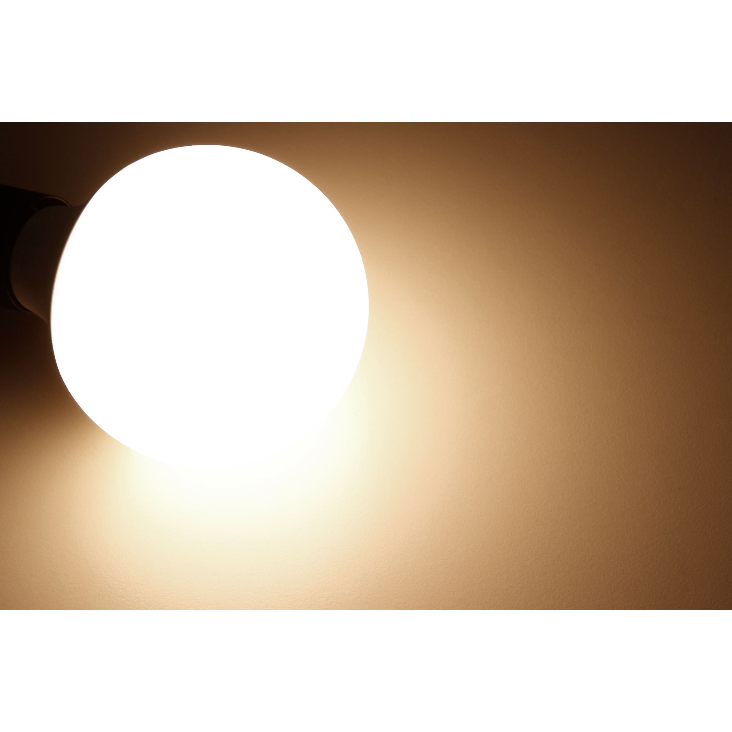 Eine helle Glühbirne an einer braunen Wand, die ein warmes Licht wirft.