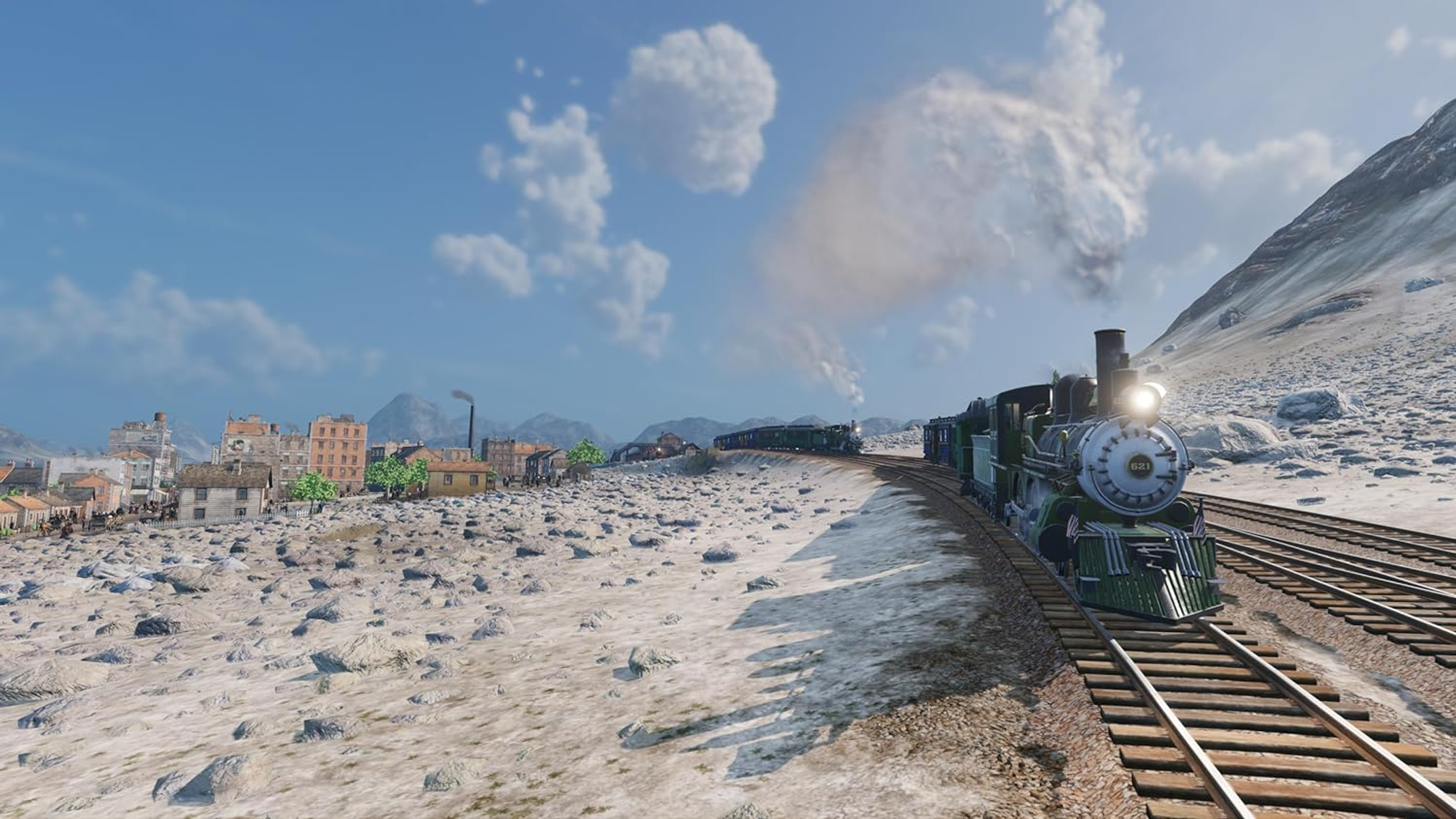 Treno sui binari, che fa una curva. Montagne sullo sfondo, cielo nuvoloso.