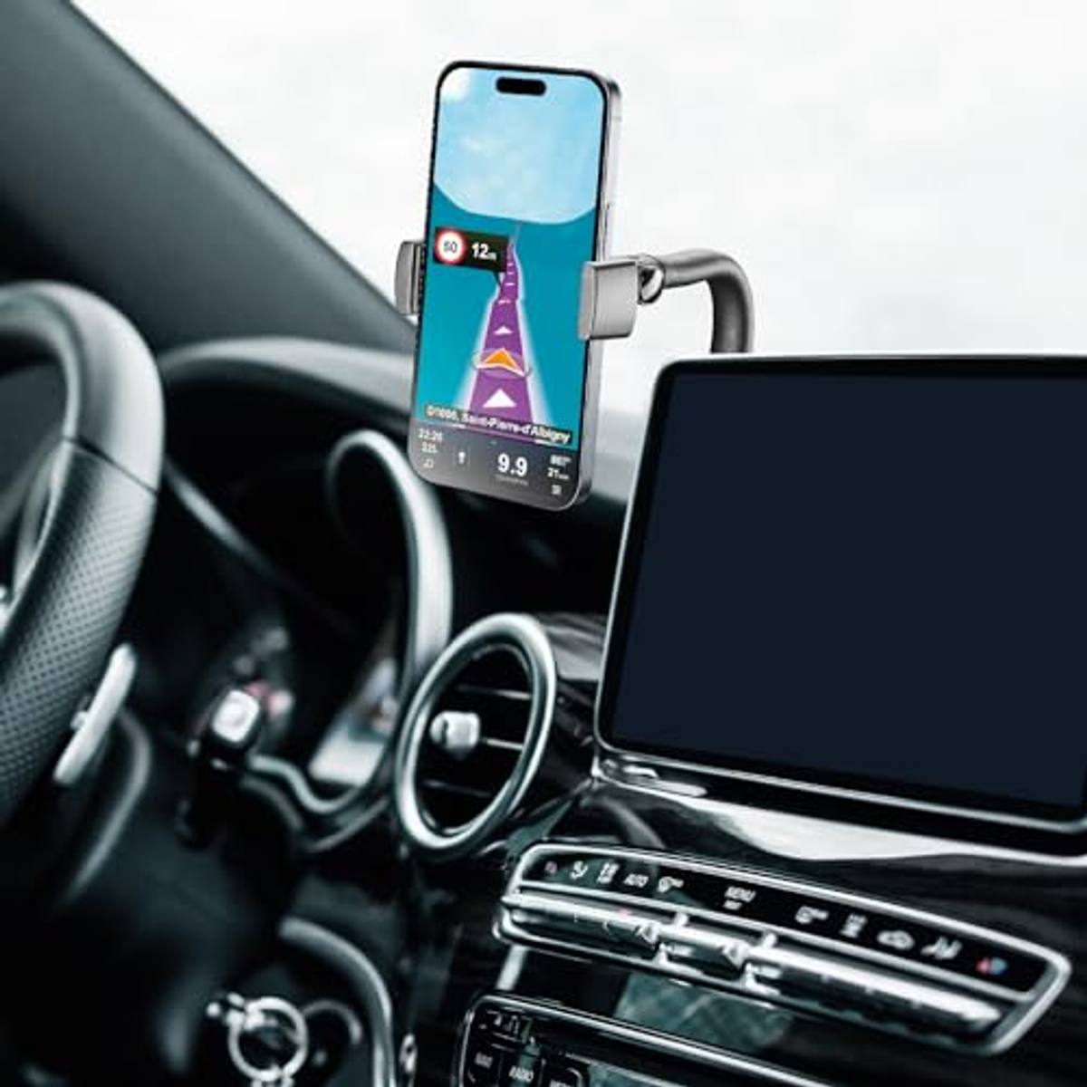 Un telefono in un supporto per auto mostra un'app di navigazione; dettagli del cruscotto visibili.
