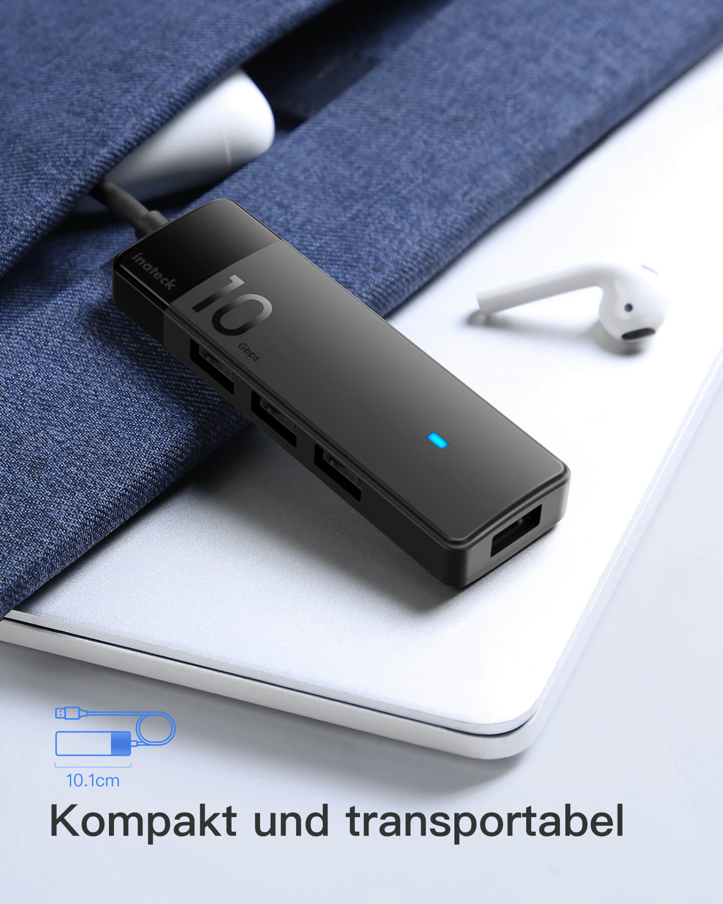 Ein schwarzer USB-Hub auf einem Laptop. Ein weißer Ohrhörer liegt daneben. Text: '10 Gbit'.