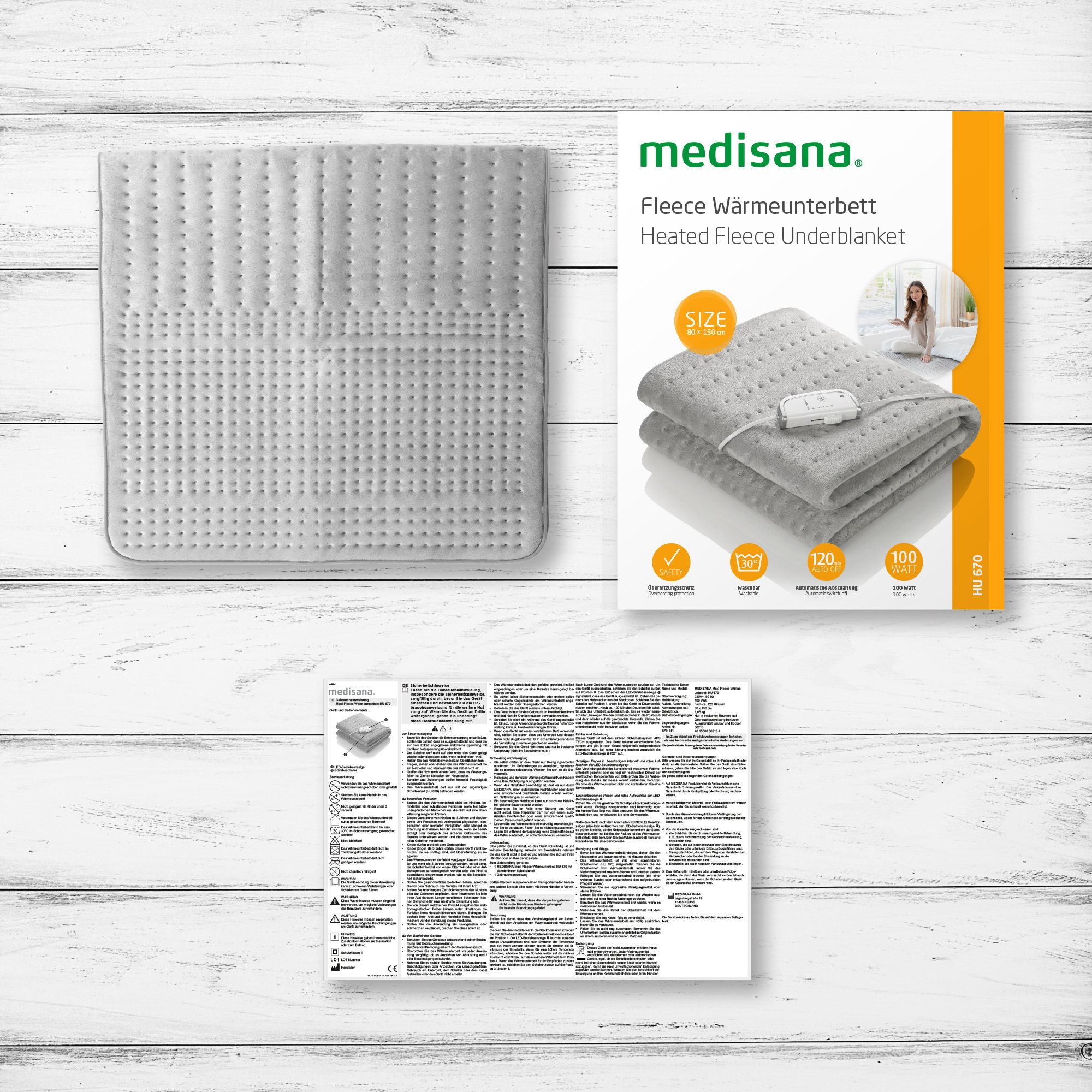 White heated underblanket with a package and instructions on a wooden surface.
