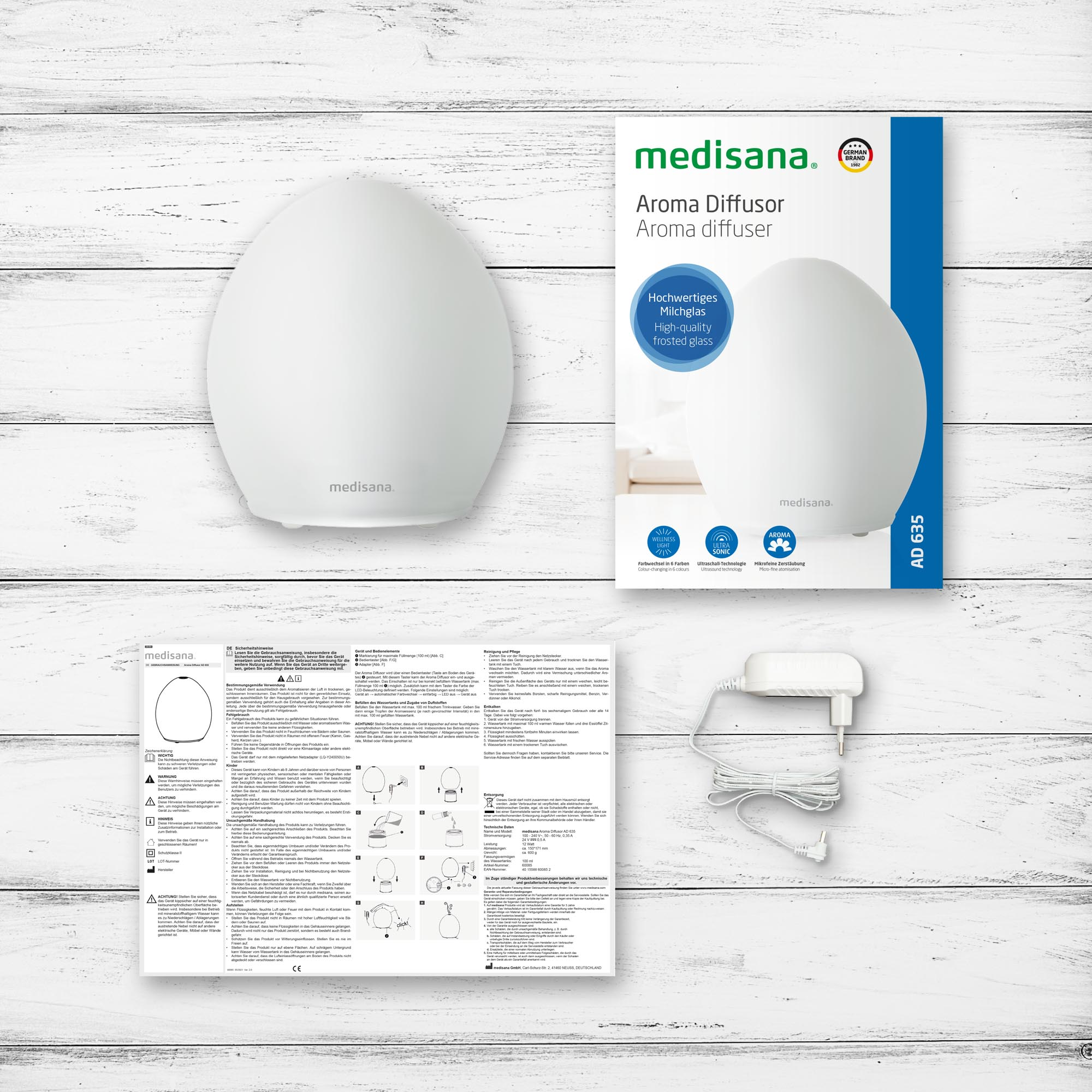 White aroma diffuser with packaging, instructions, and power adapter. 
