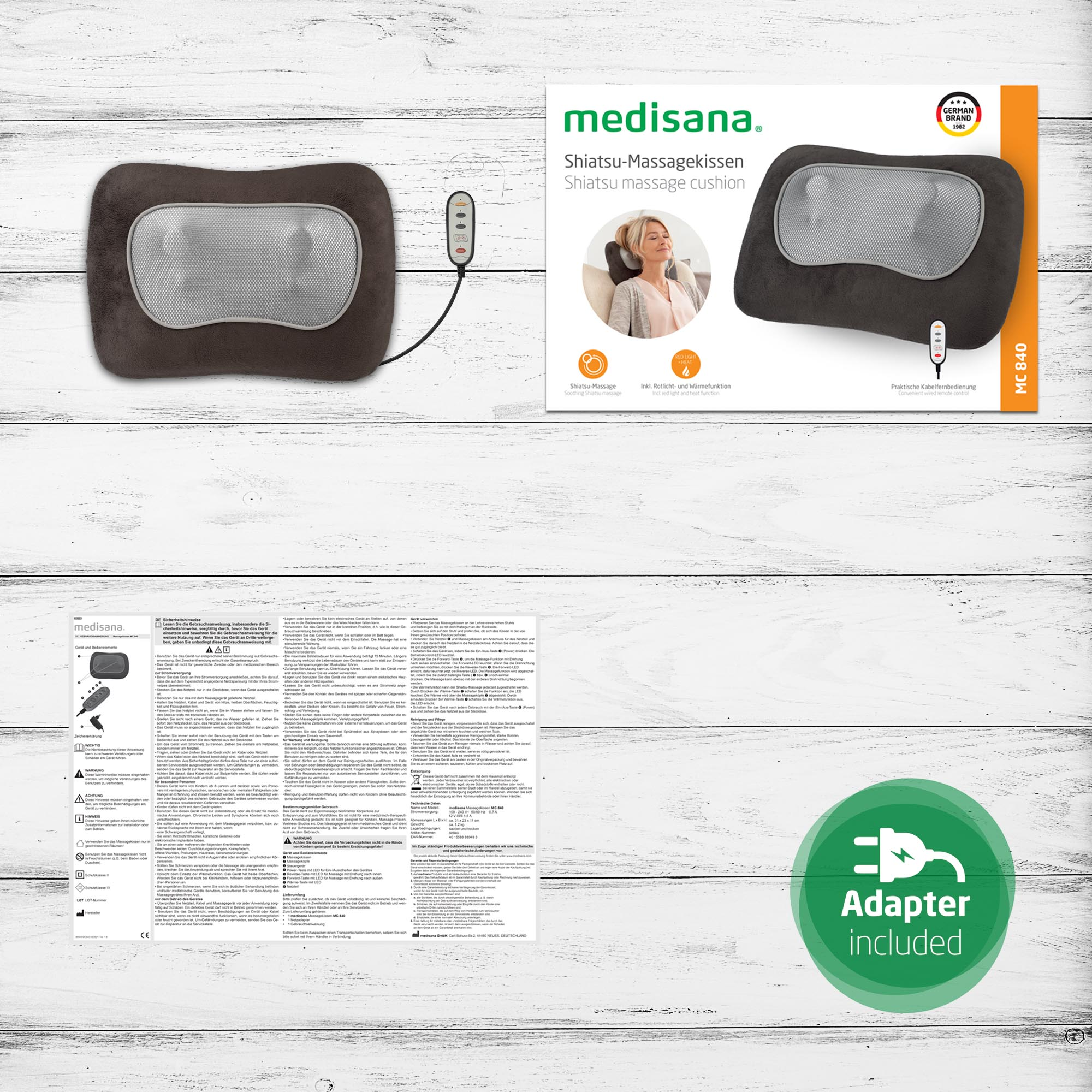 Ein Massagekissen und seine Box, Bedienungsanleitung und ein Adapter.