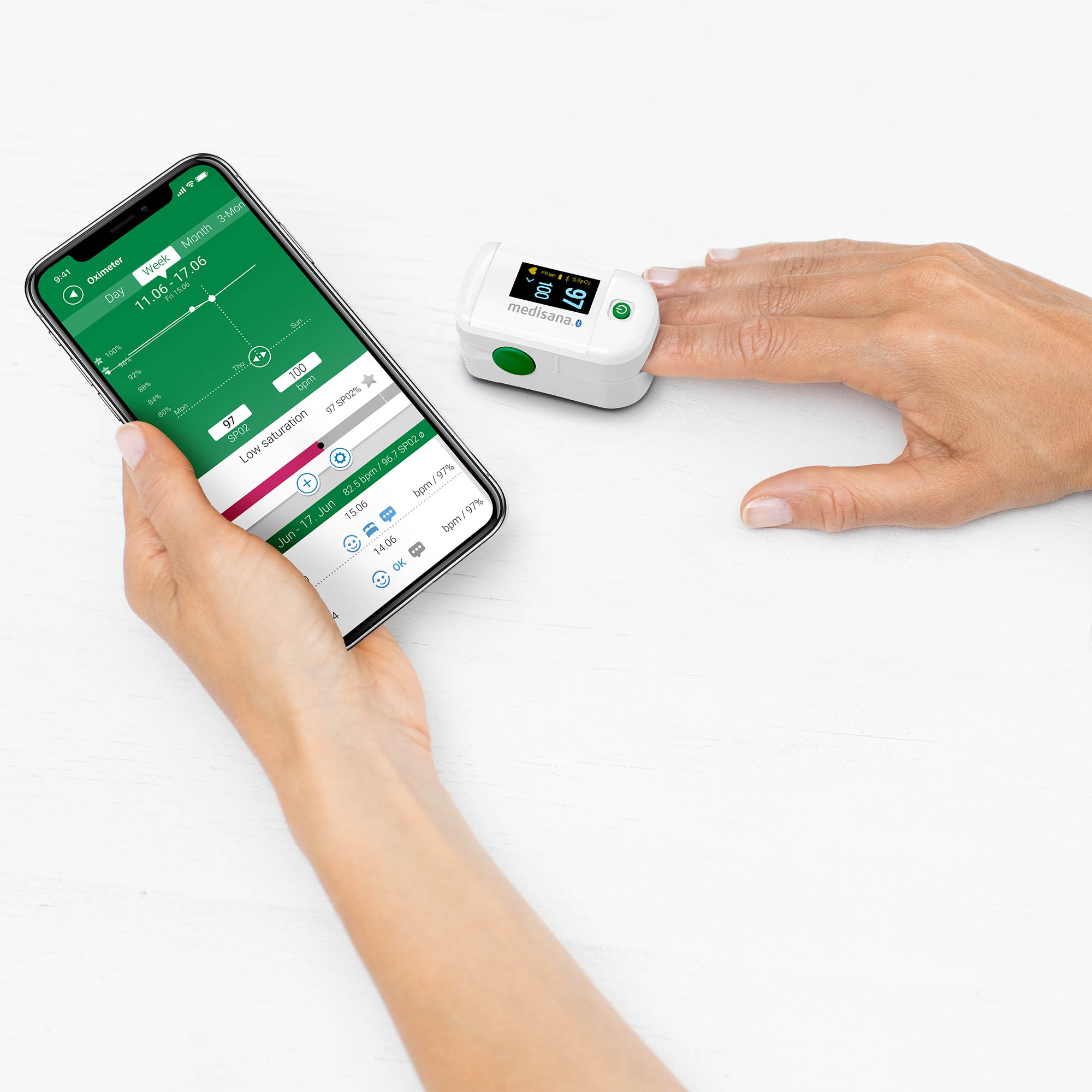 Osoba trzyma smartfona i urządzenie medyczne, wyświetlając dane zdrowotne na ekranie.