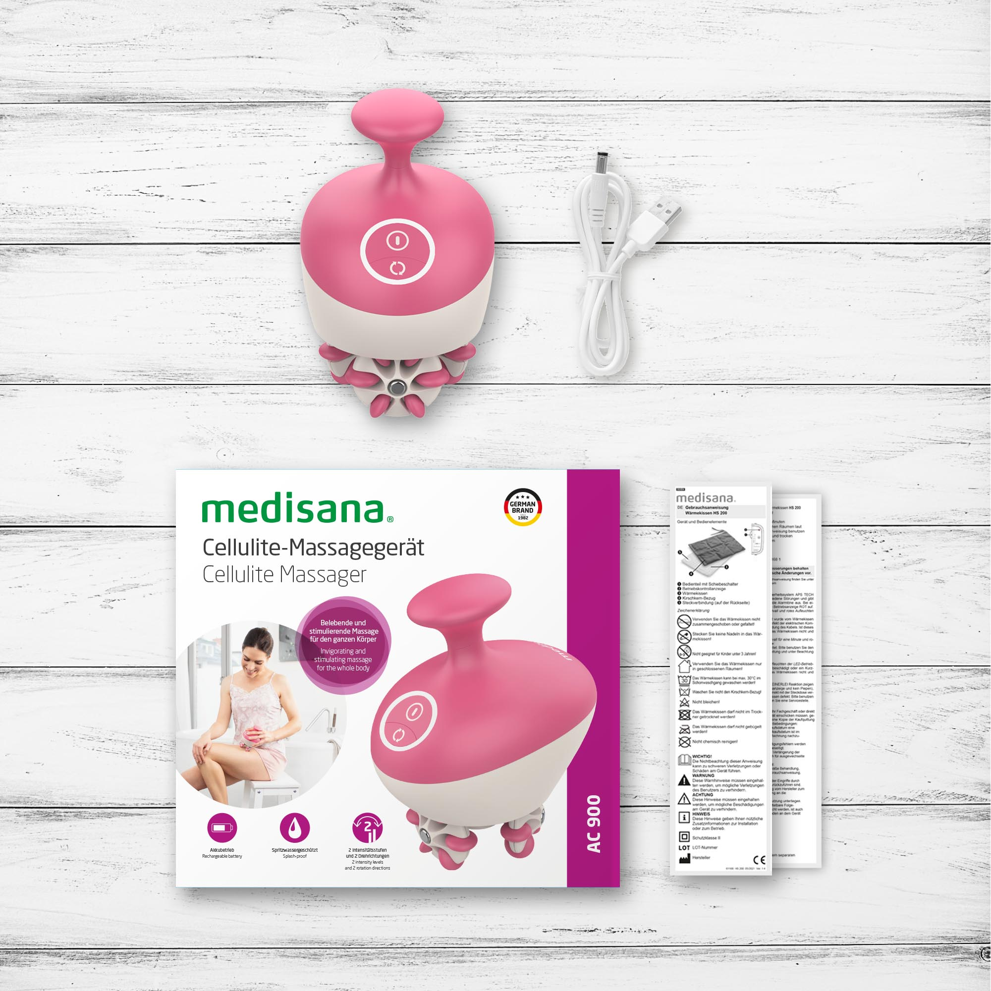 Pink cellulite massager, box with image of use, and instructions against a wooden background.