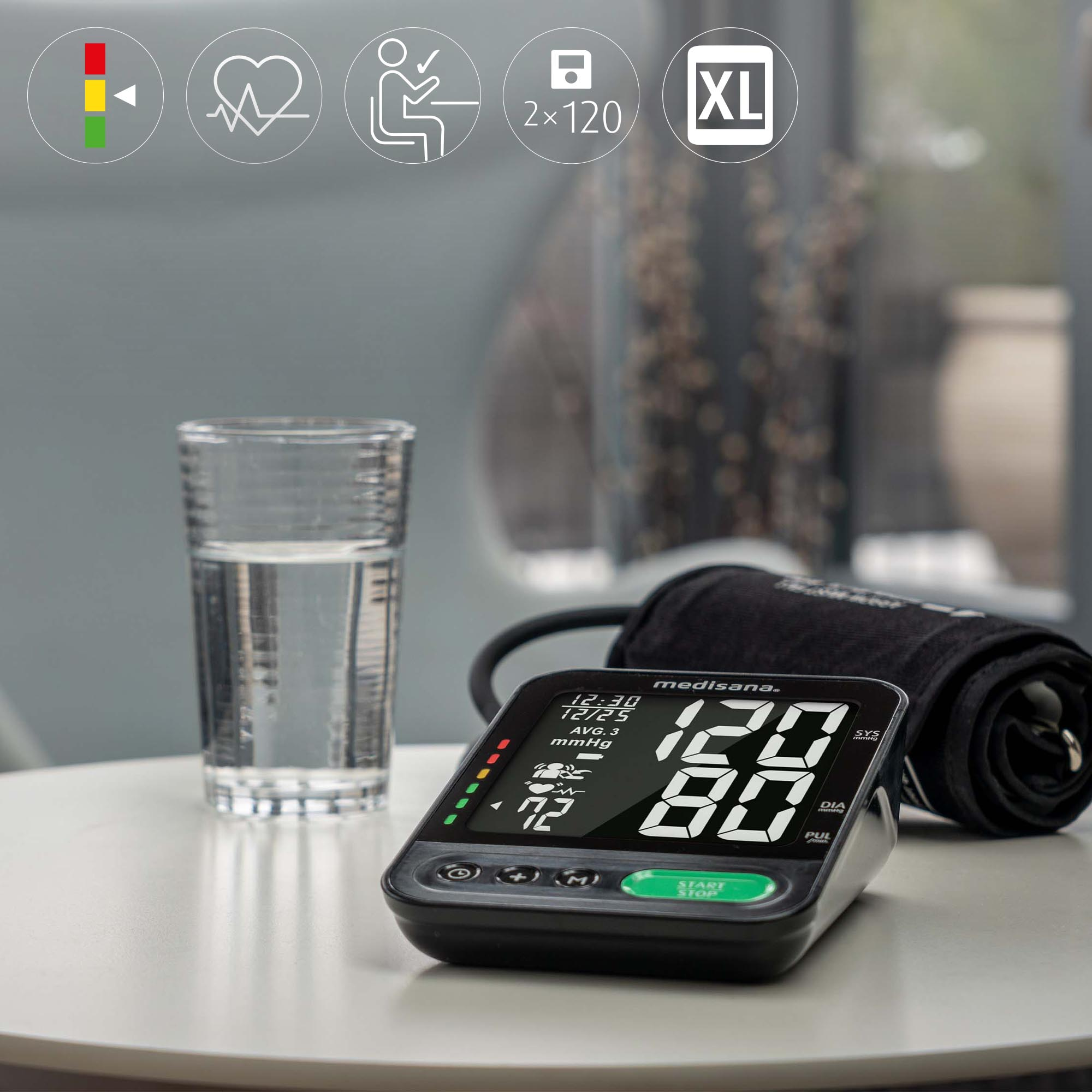 Ciśnieniomierz na stole z szklanką wody. Ikony i odczyty na ekranie.