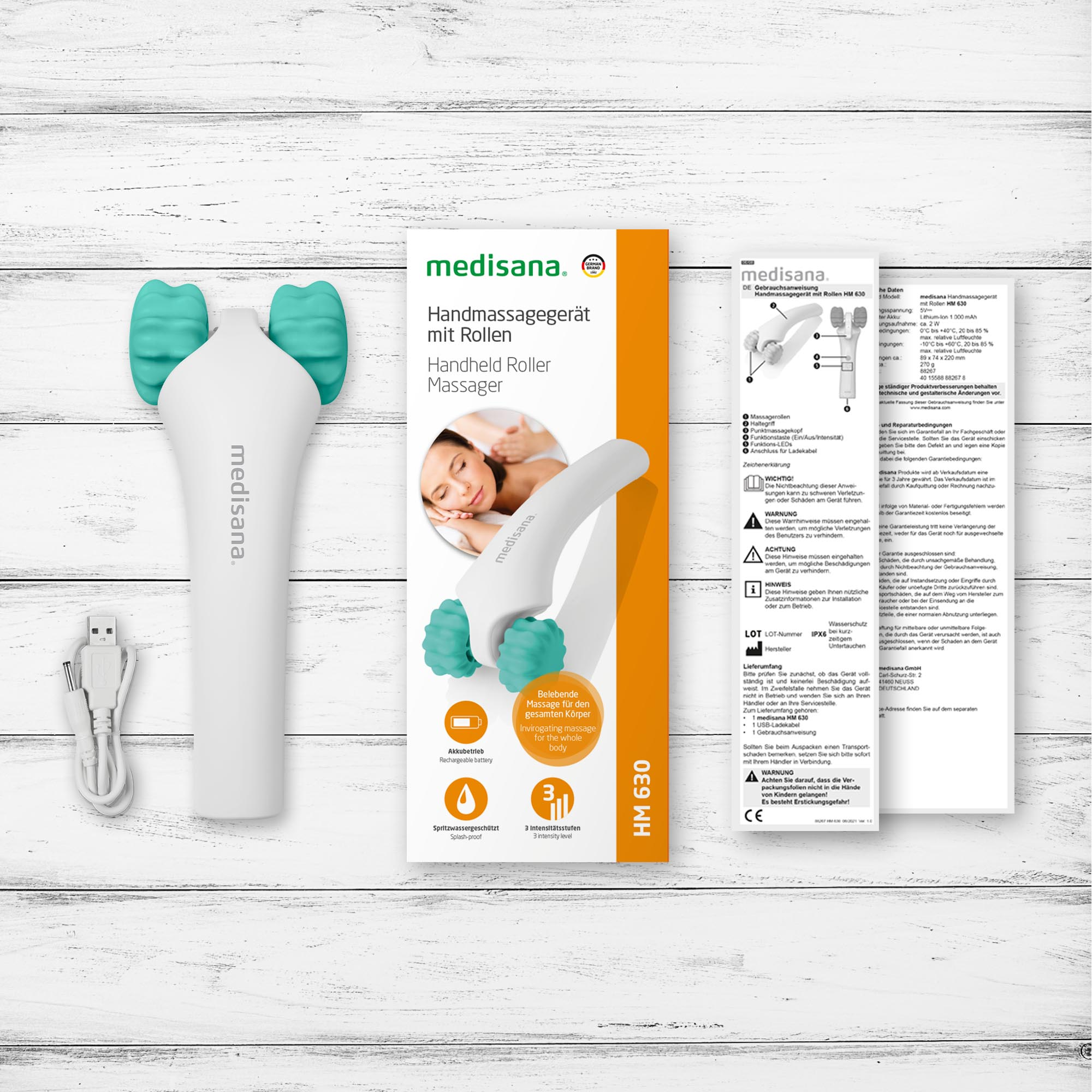 Weißes Hand-Rollmassagegerät mit teal Rollen. Verpackung zeigt Produkt und Frau. Inklusive USB-Kabel.