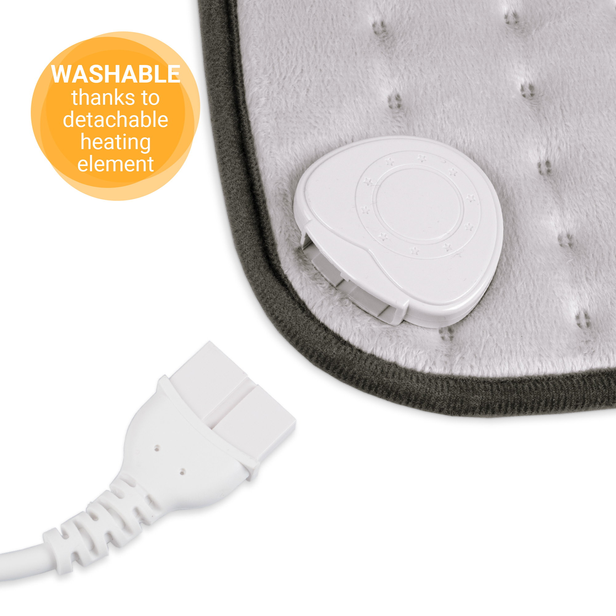 An image of a laptop on a white surface, with a cable and a small white device.