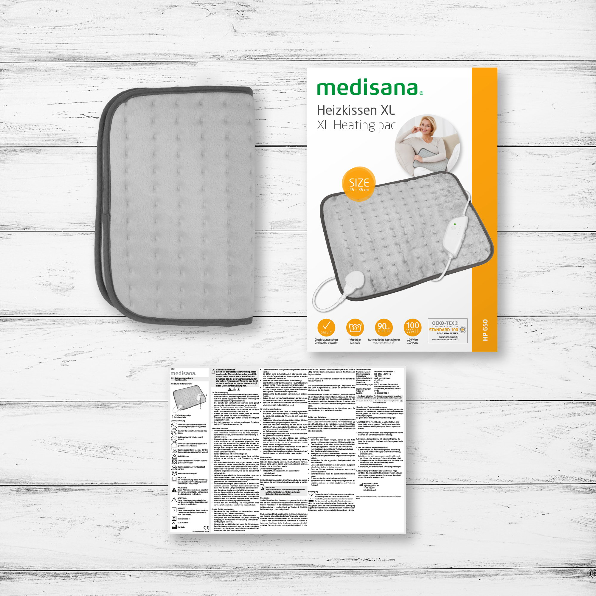 A gray heating pad and box with instructions on a wooden surface, top view.
