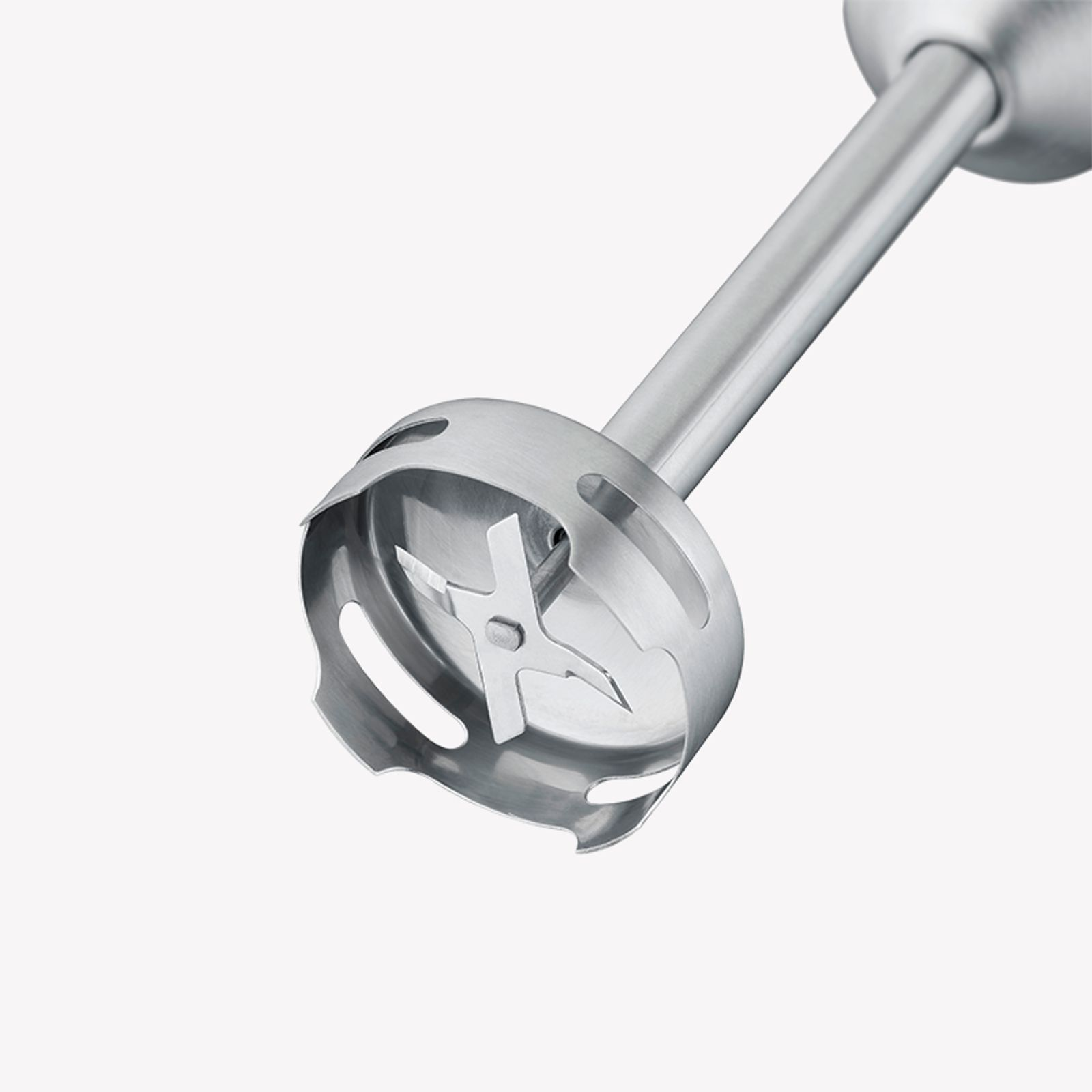 Close-up of a blender blade. The blades are inside a metal guard, angled towards camera.