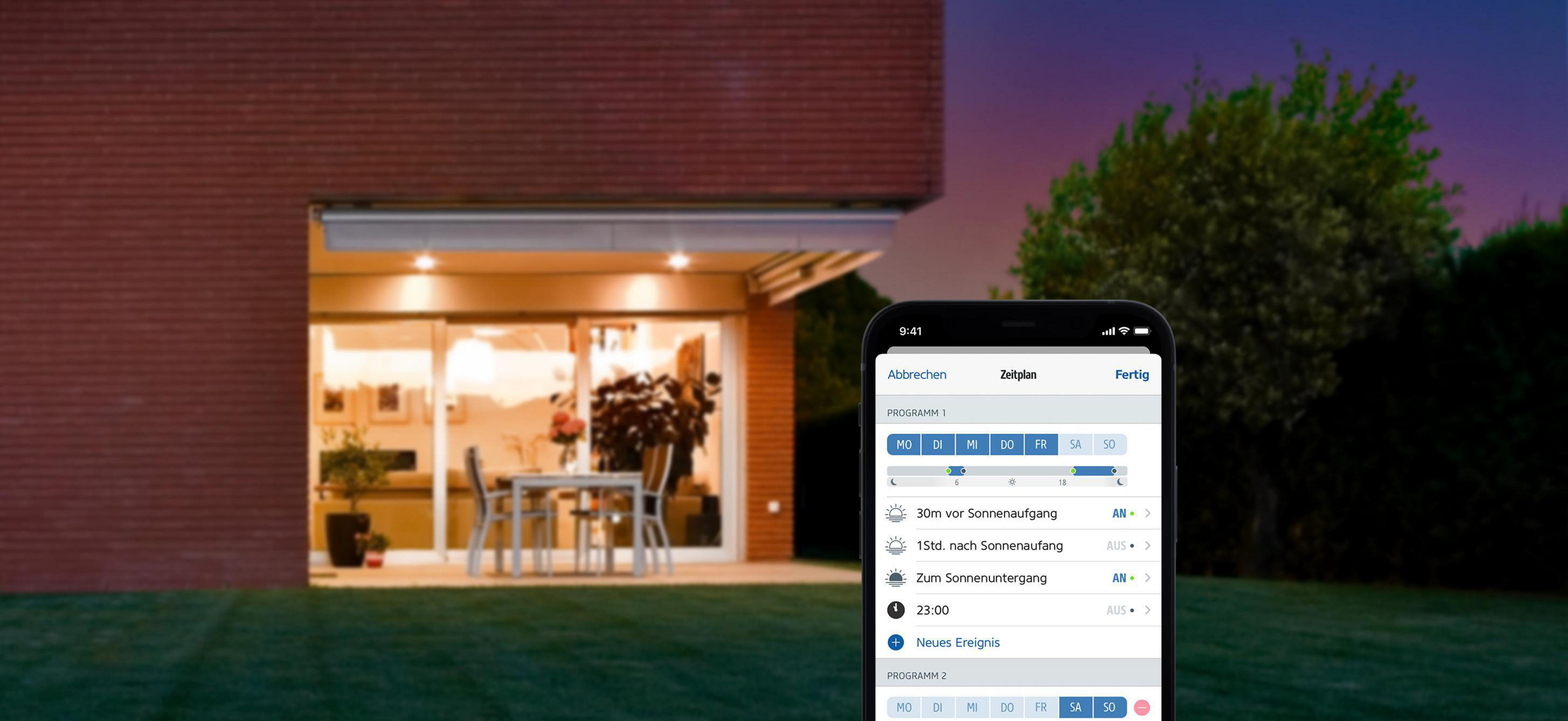 Una casa con patio, un telefono che mostra un programma temporale sul suo schermo.