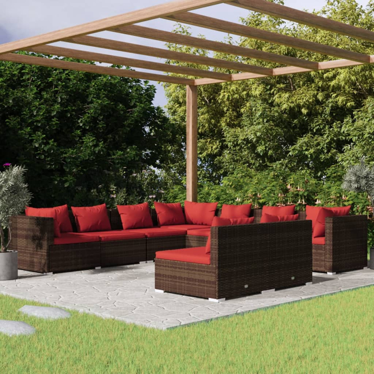 Terrassenmöbel-Set im Freien mit braunem Korbmöbel mit roten Kissen, unter einer Holzpergola, mit grünem Gras.