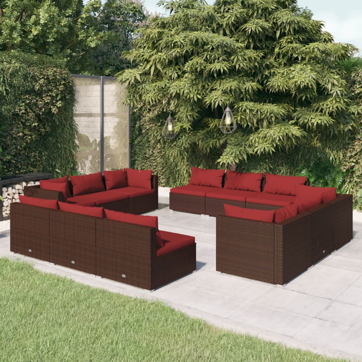 Großes Outdoor-Terrassenset mit roten Kissen. Dunkelbraune Korbmöbel auf einer Terrasse, umgeben von Grün.