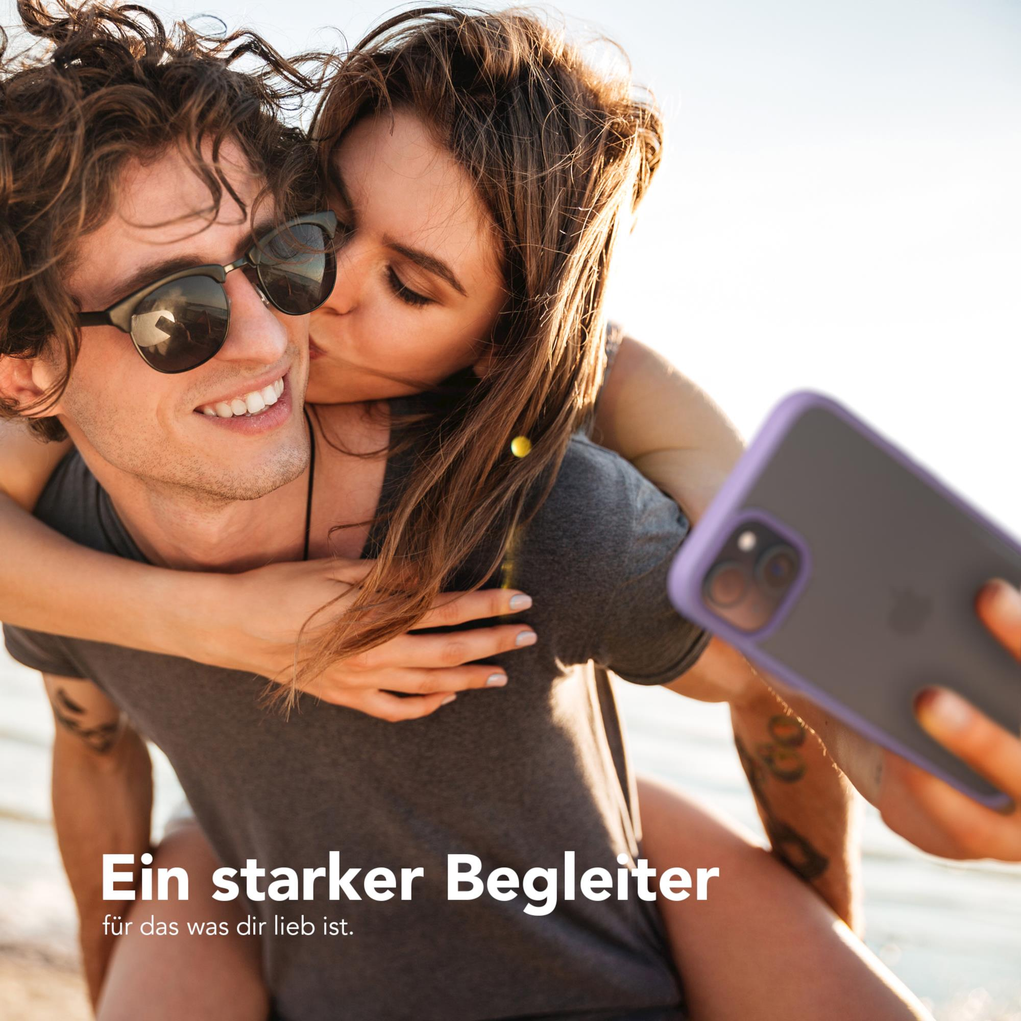 Ein Mann und eine Frau umarmen sich. Die Frau küsst den Mann auf die Wange. Sie halten ein Telefon.