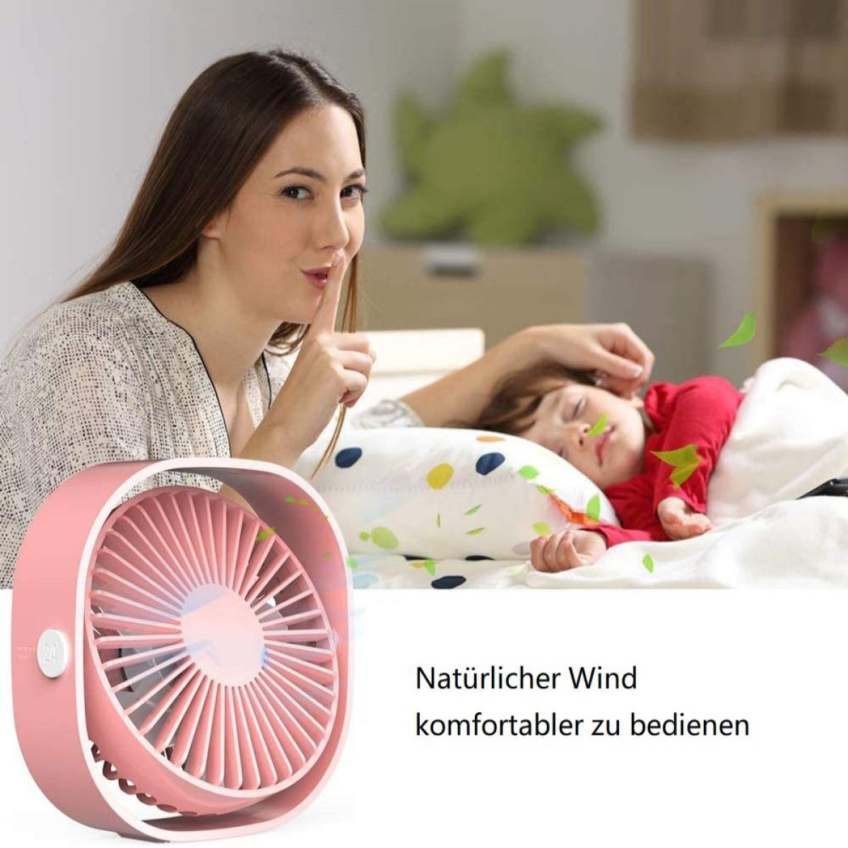 Eine Frau deutet Stille in der Nähe eines rosa Ventilators an. Ein Kind schläft auf einem Bett, Blätter wehen.