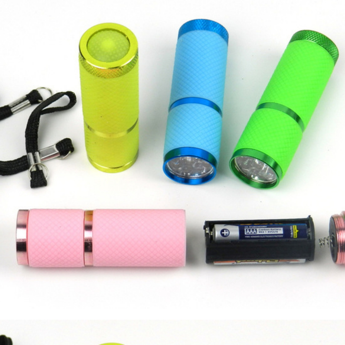 Vier Taschenlampen in verschiedenen Farben und eine zerlegte Taschenlampe mit Batterien.