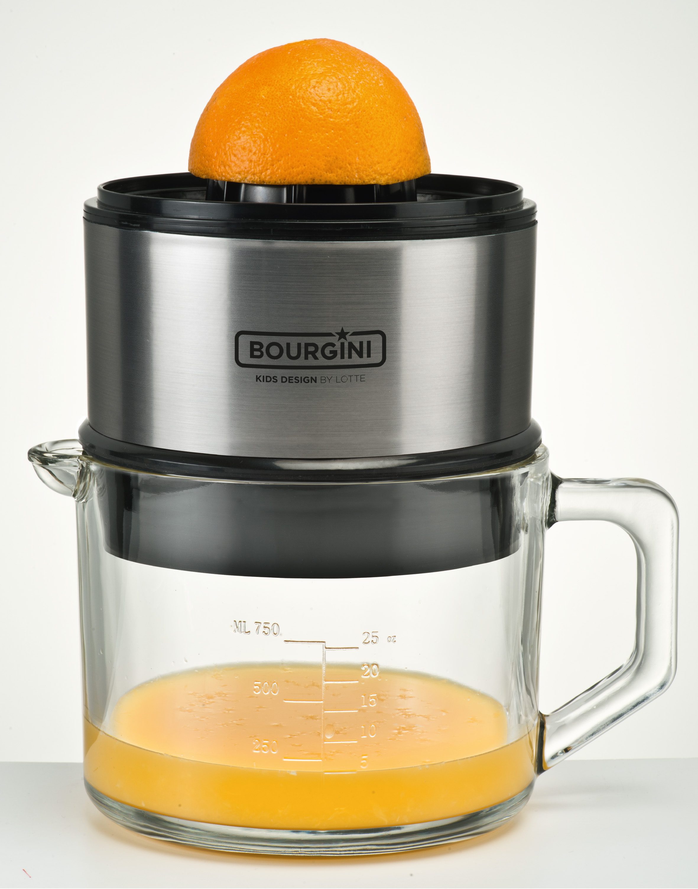 Naranja a medias en exprimidor. Jarra de vidrio con jugo de naranja. Exprimidor plateado y negro.