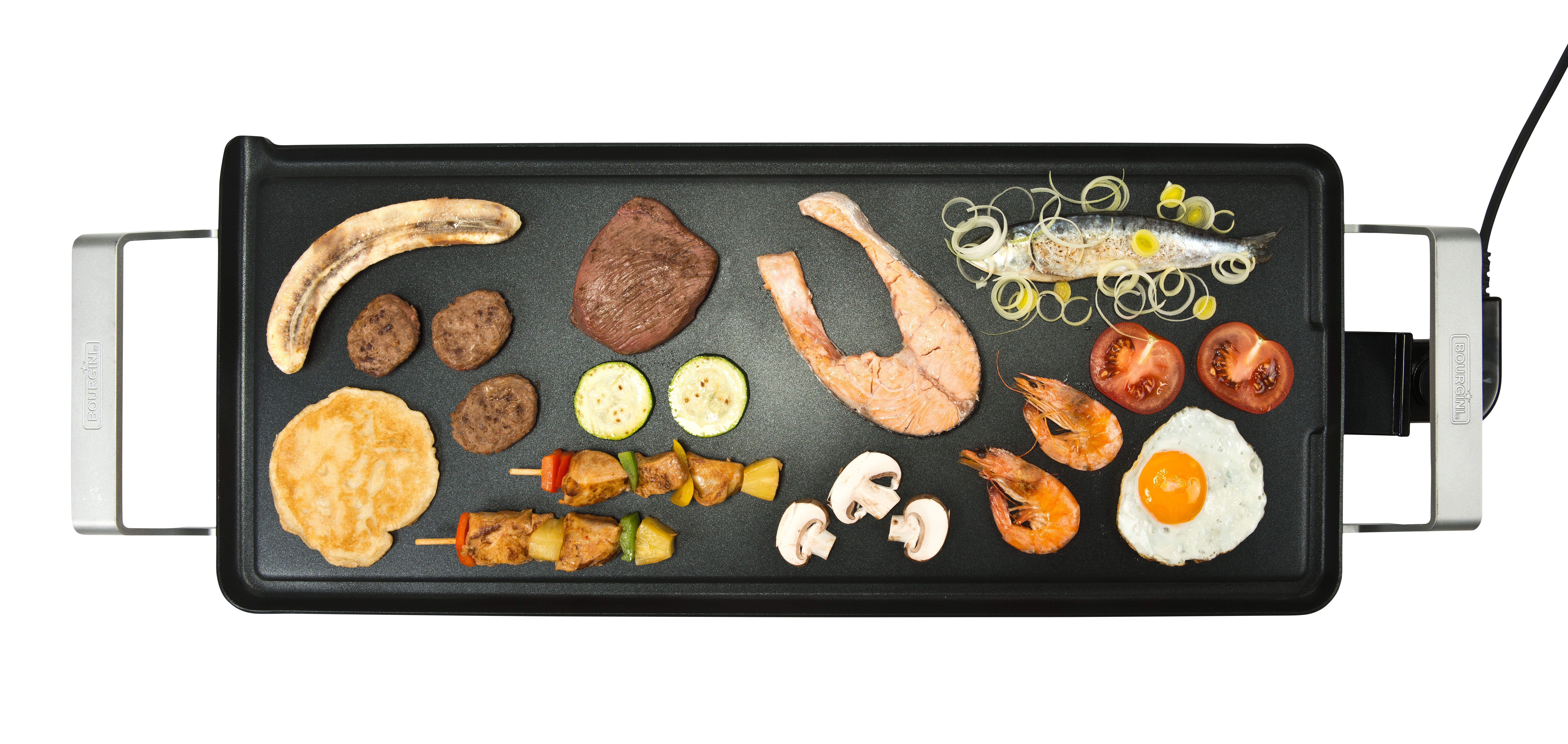 Griddle with cooked food: banana, burger, steak, salmon, shrimp, tomatoes, and egg.
