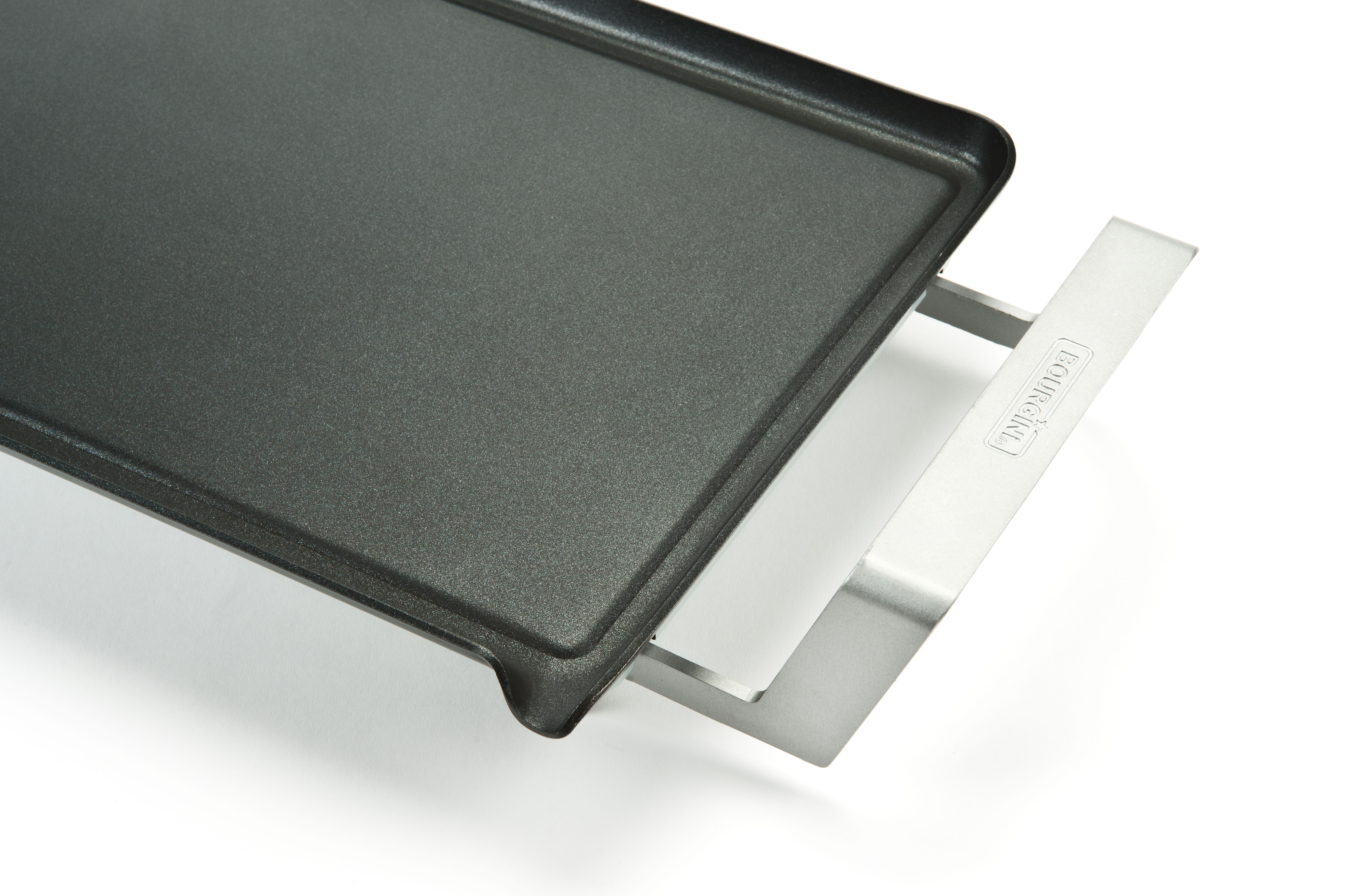 Black griddle on a white surface with a silver handle.