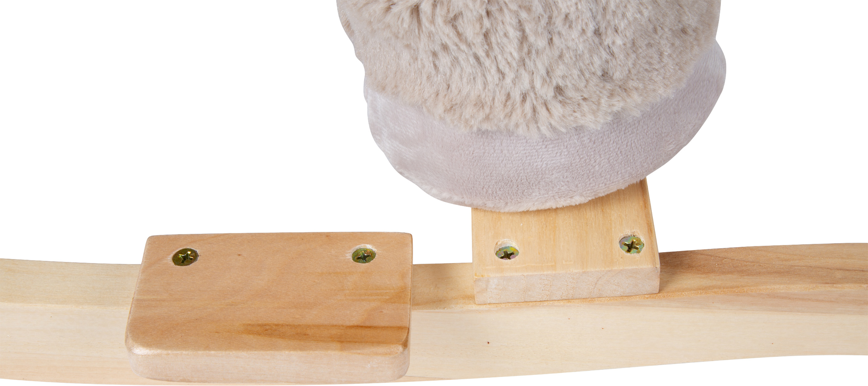 Ein flauschiges, helles Objekt liegt auf Holzblöcken, die auf eine Holzplatte geschraubt sind.