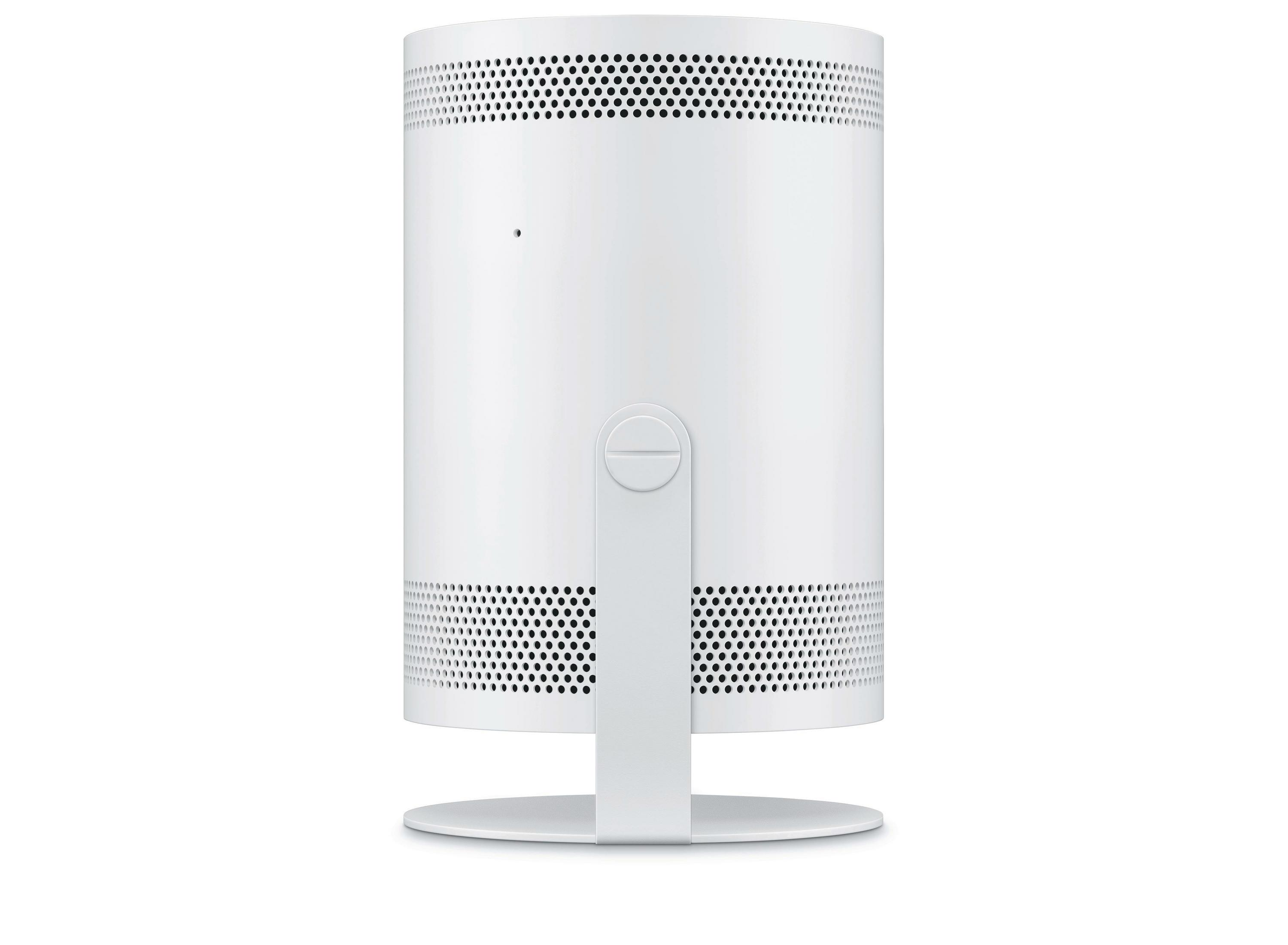 Biały projektor z okrągłą podstawą i małym obiektywem z tyłu na białym tle.