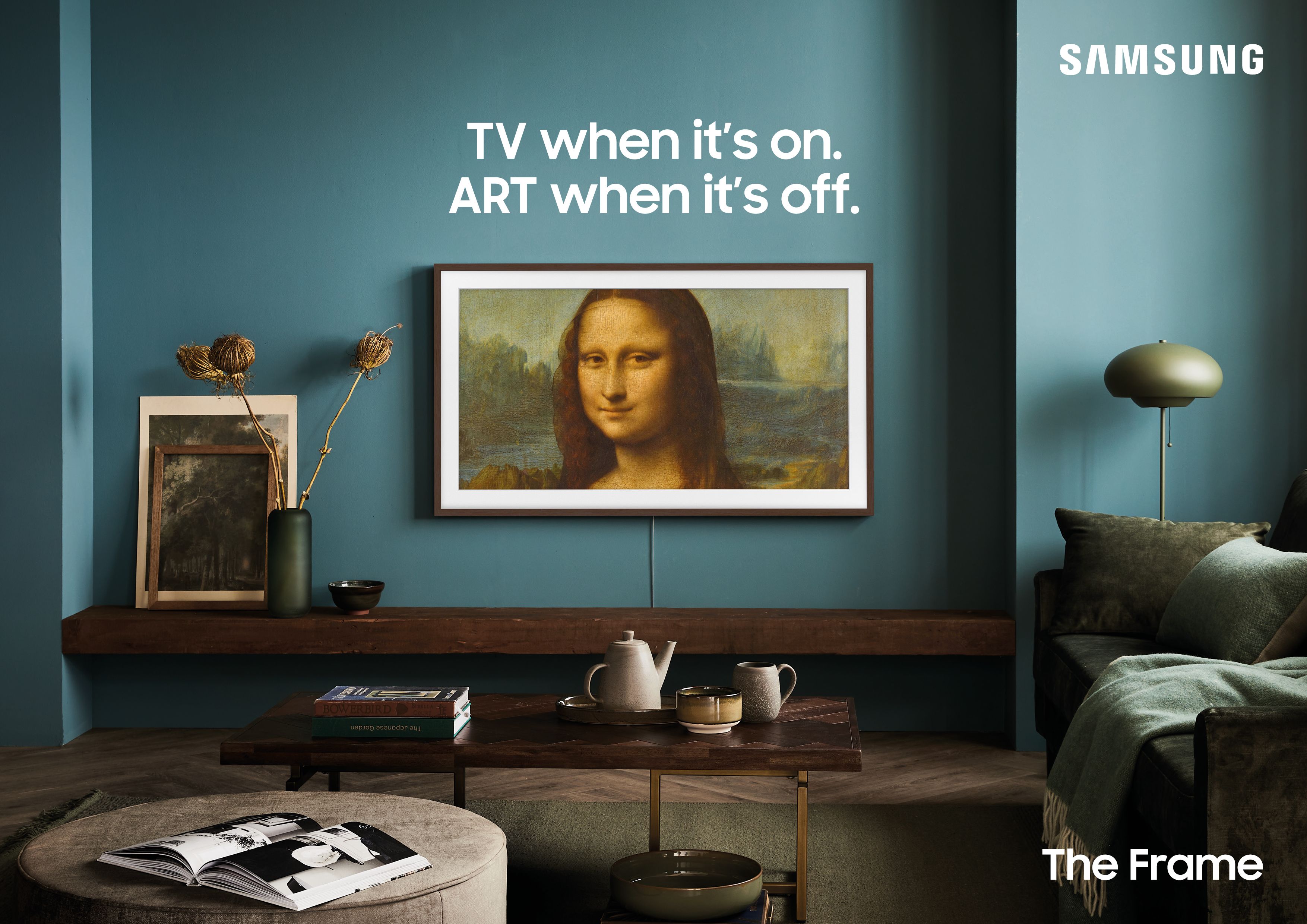 Obraz Mona Lisy na ekranie telewizora. Pokój ma turkusową ścianę i drewnianą półkę.