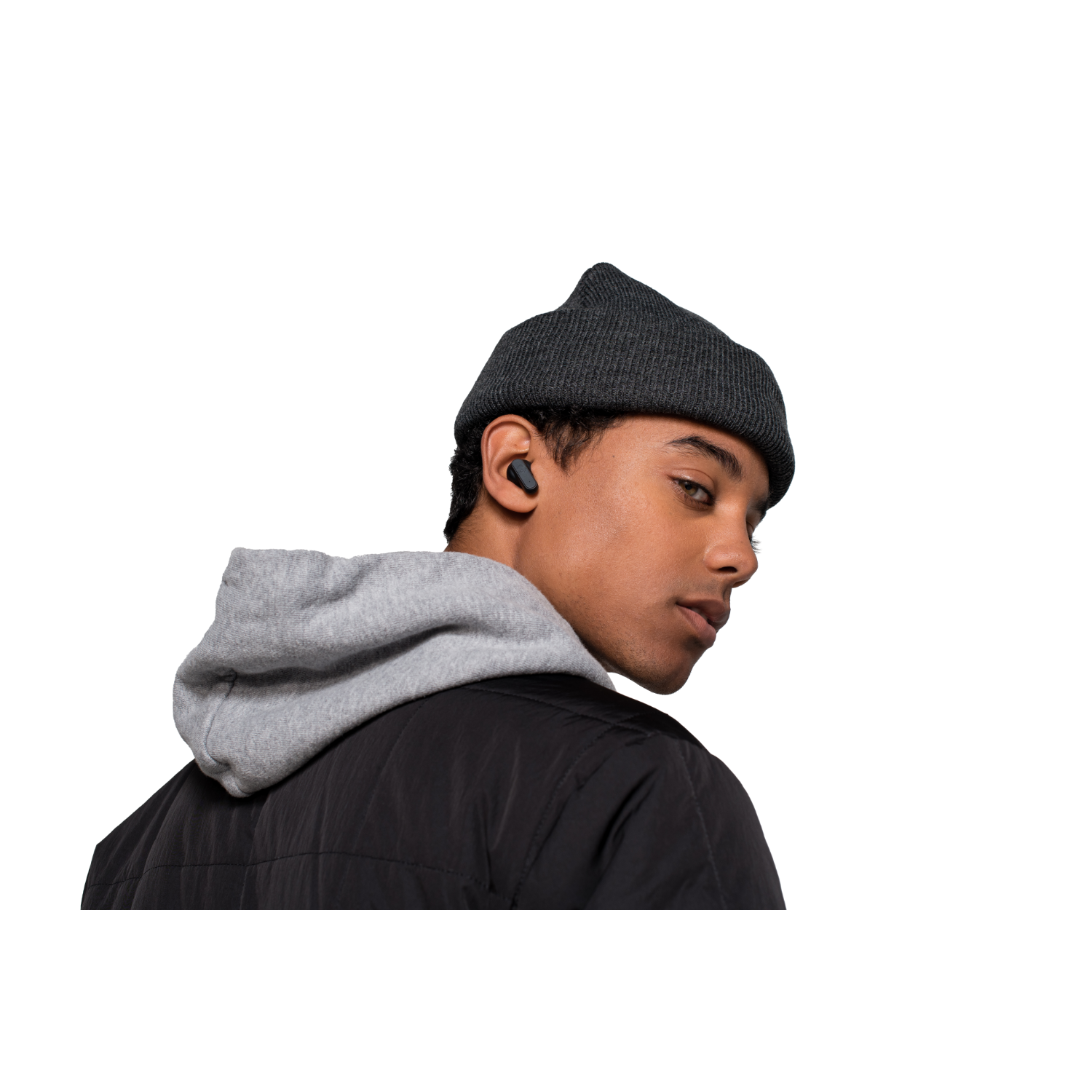 Młody mężczyzna w czapce i szarej bluzie z kapturem, ze słuchawkami, spoglądający przez ramię.