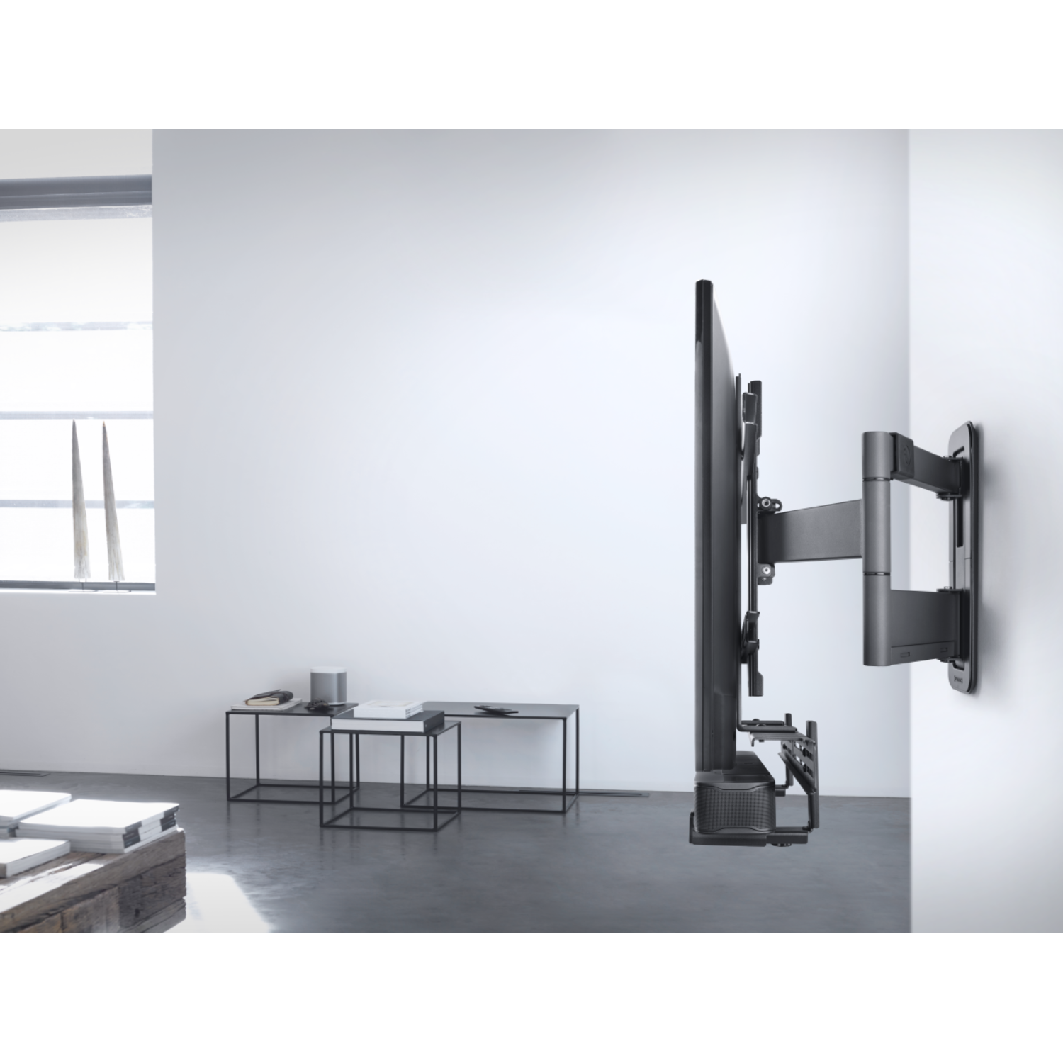 Een grote tv aan de muur gemonteerd, met een zwart frame en veel ruimte.