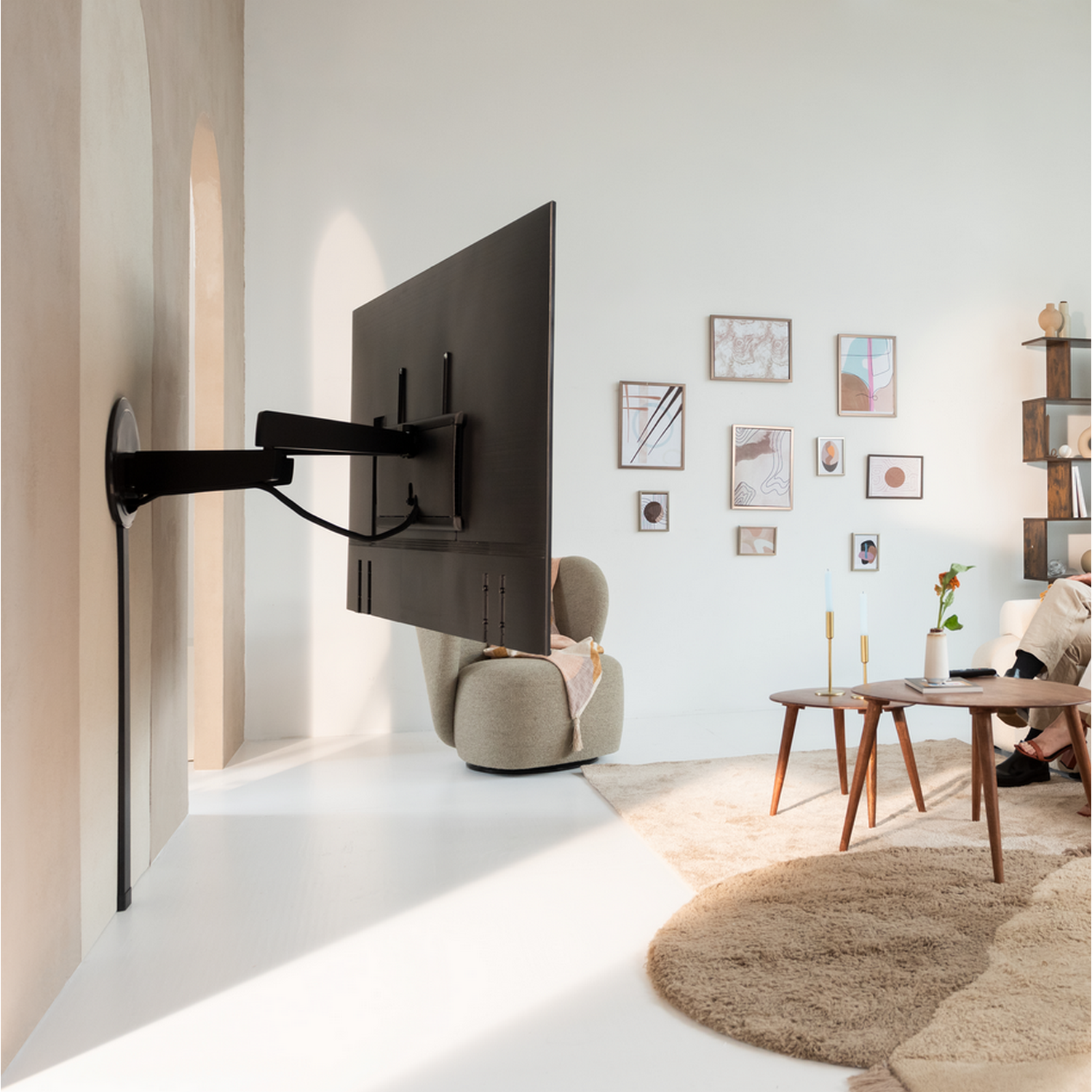 Un grand téléviseur mural dans un salon moderne avec des meubles et de la décoration.