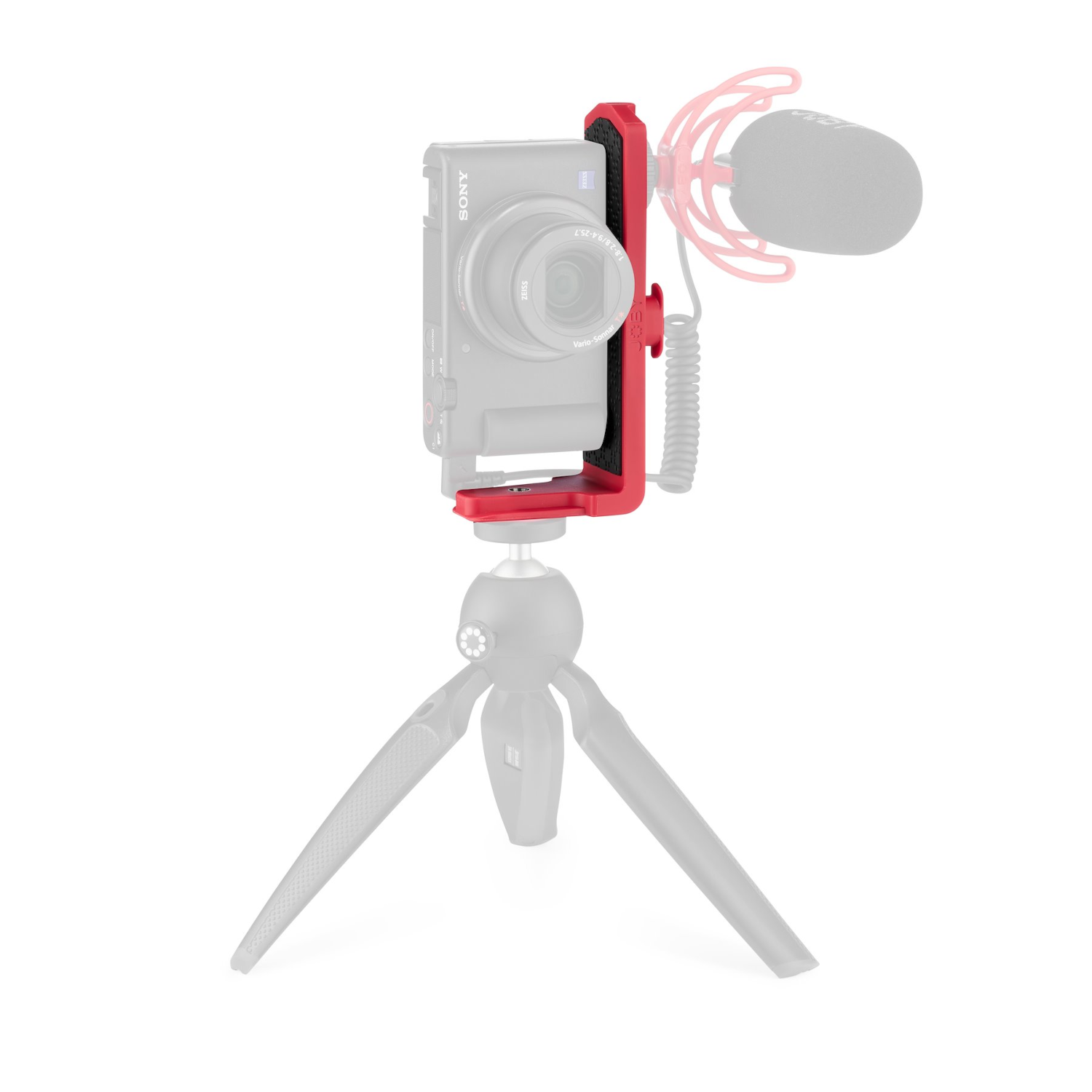 Una fotocamera montata su una staffa rossa, con un microfono, su un treppiede.