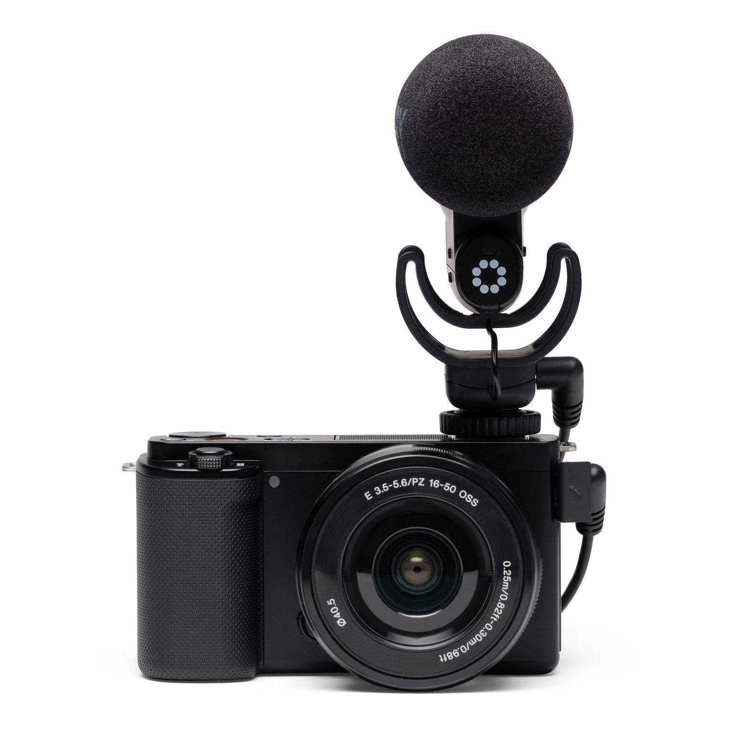 A black camera with a microphone attached. It has a lens and a screen.
