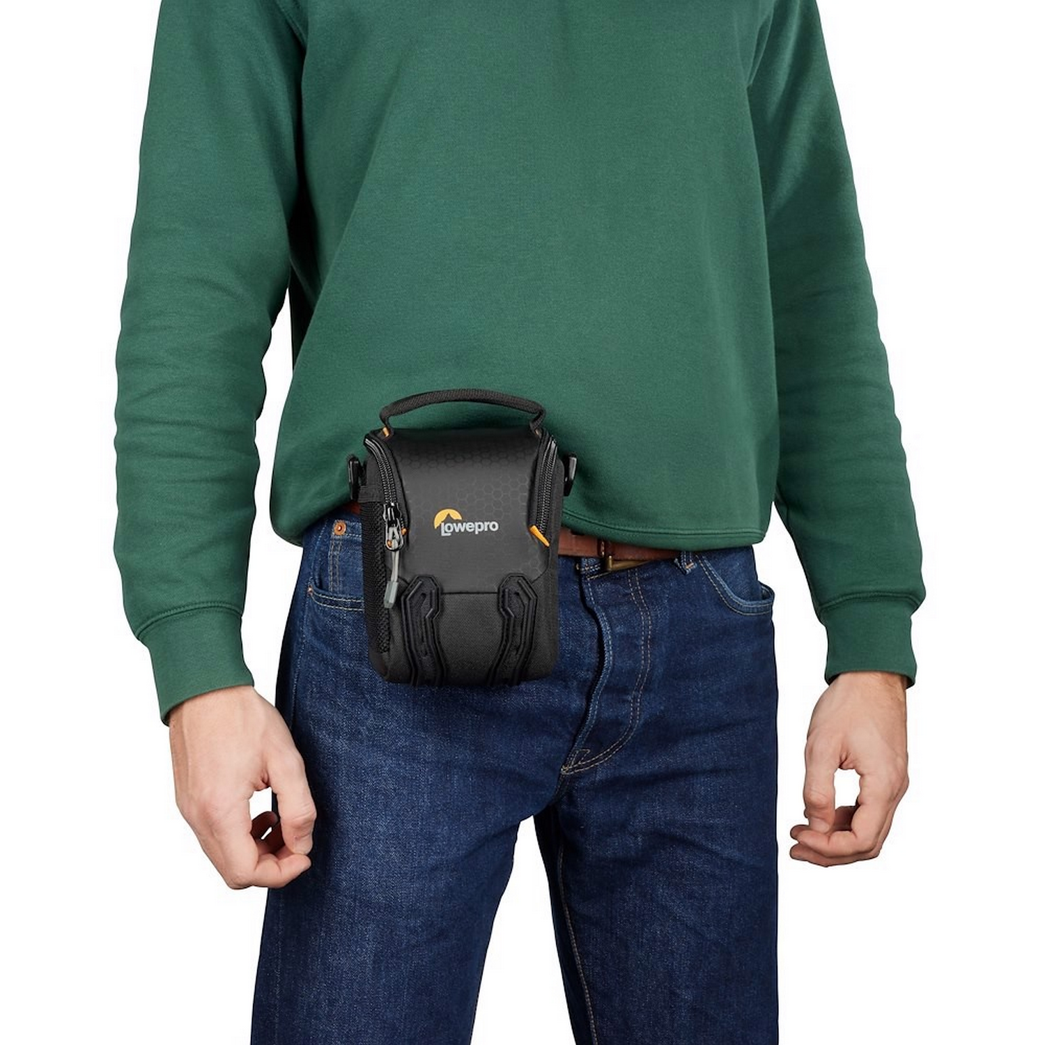 Man wearing a green sweater and jeans, with a black camera bag on his waist.