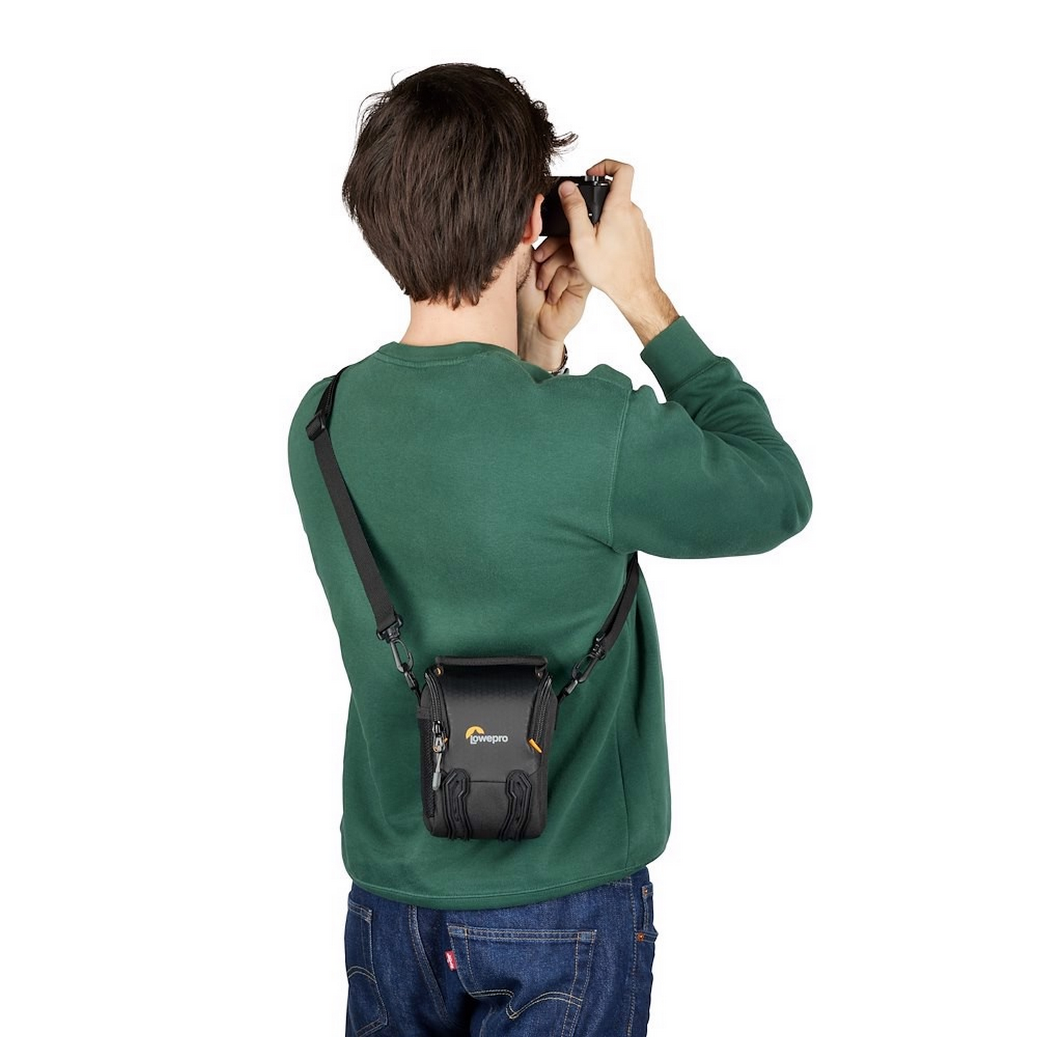 A person taking a photo with a camera. A black camera bag is on the person's waist.